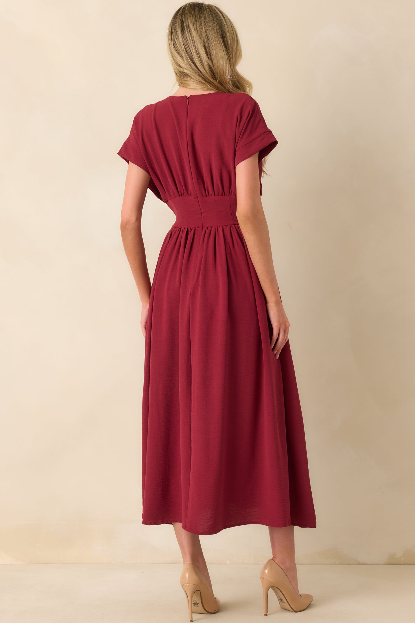Back view of the dress highlighting the hidden zipper closure and smooth burgundy fabric.