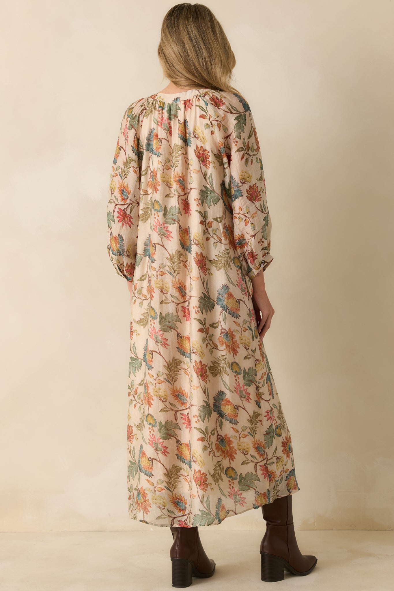 Back view of the ecru floral maxi dress, displaying its relaxed drape and continued floral pattern.