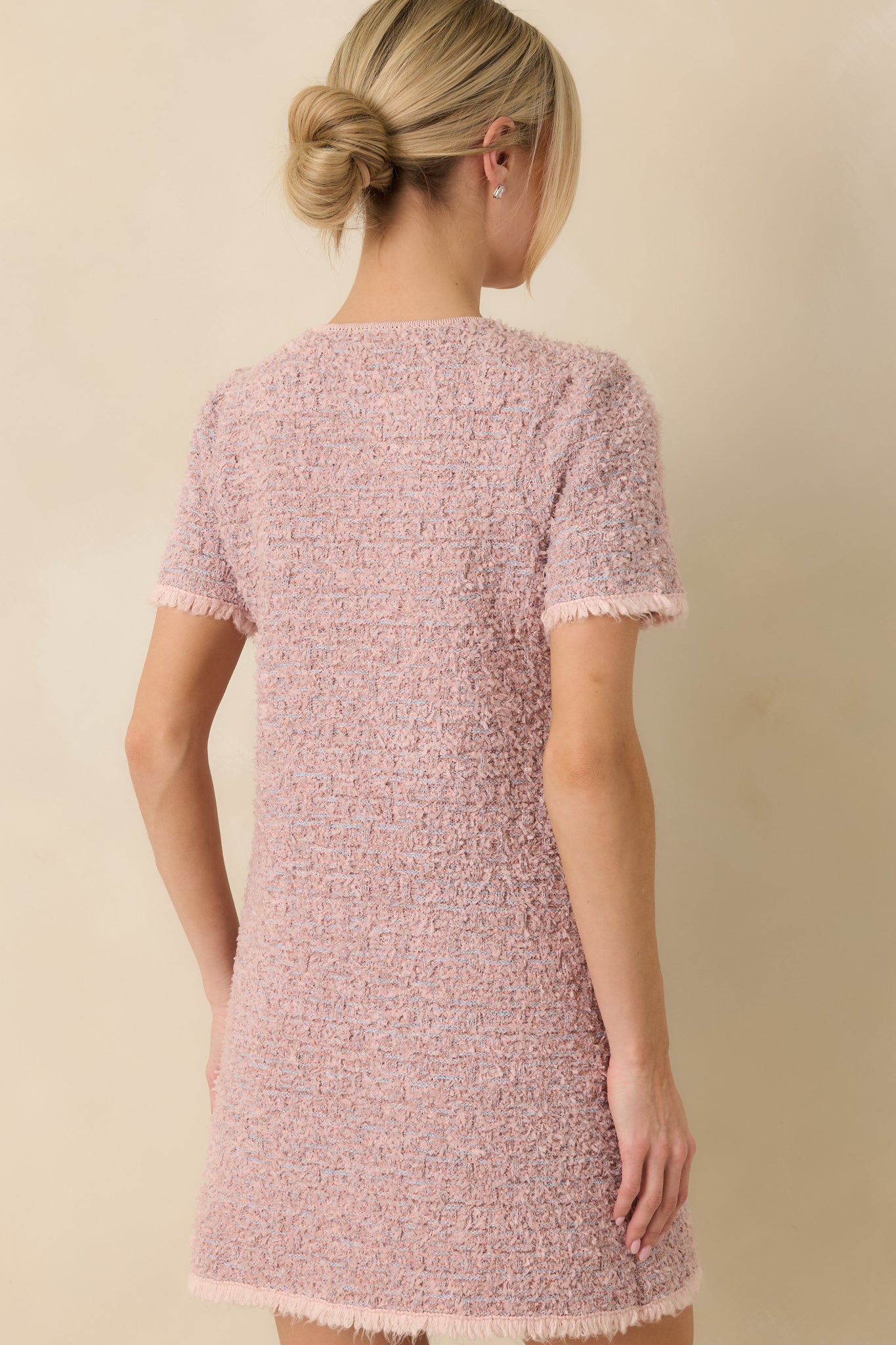 Back view of the dusty pink mini dress featuring a clean finish and subtle woven texture.
