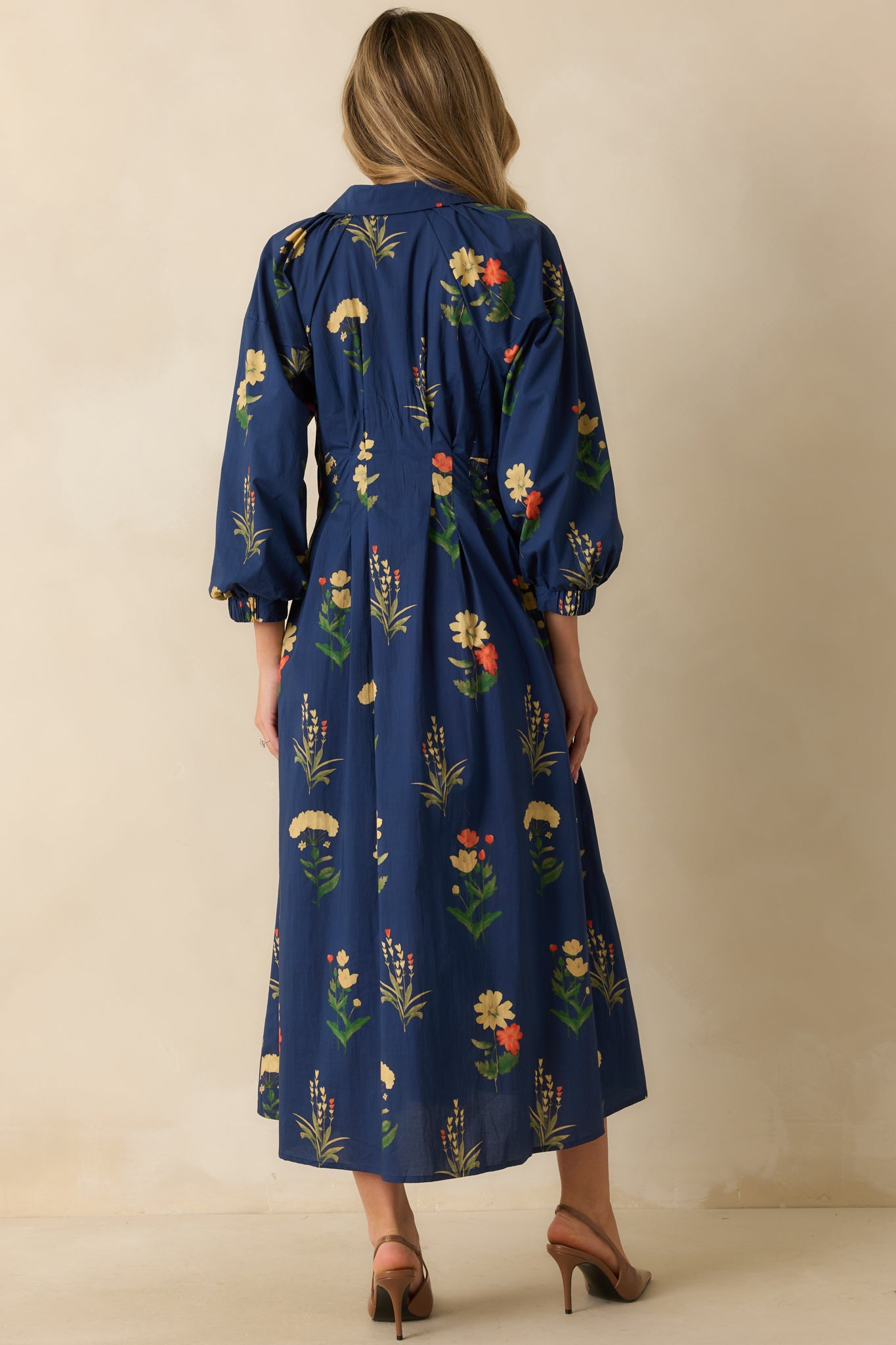 Back view of model showing the full floral pattern and long flowing skirt with soft drape.