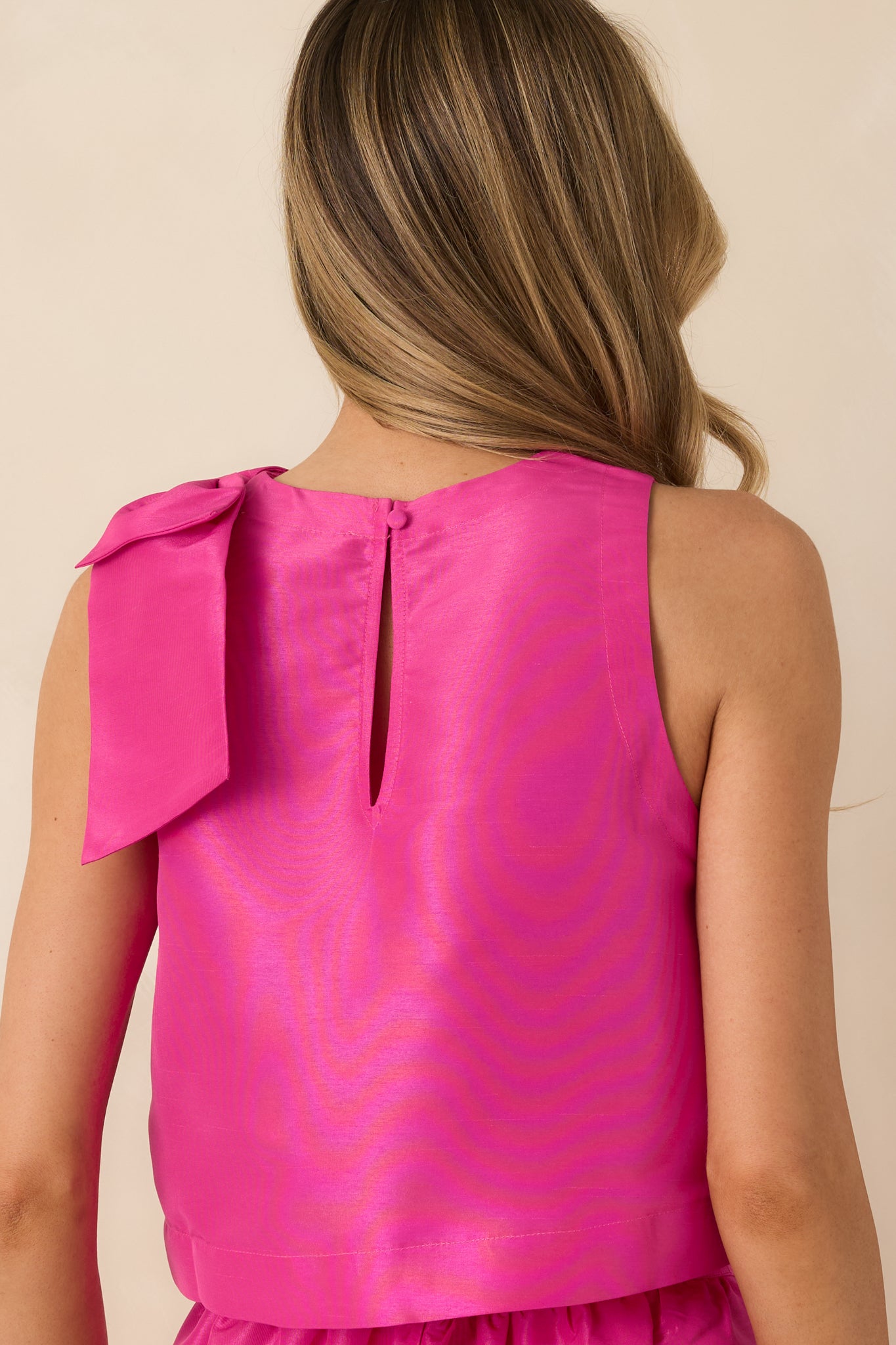 Back view of the fuchsia sleeveless top featuring the keyhole closure and straight hemline.