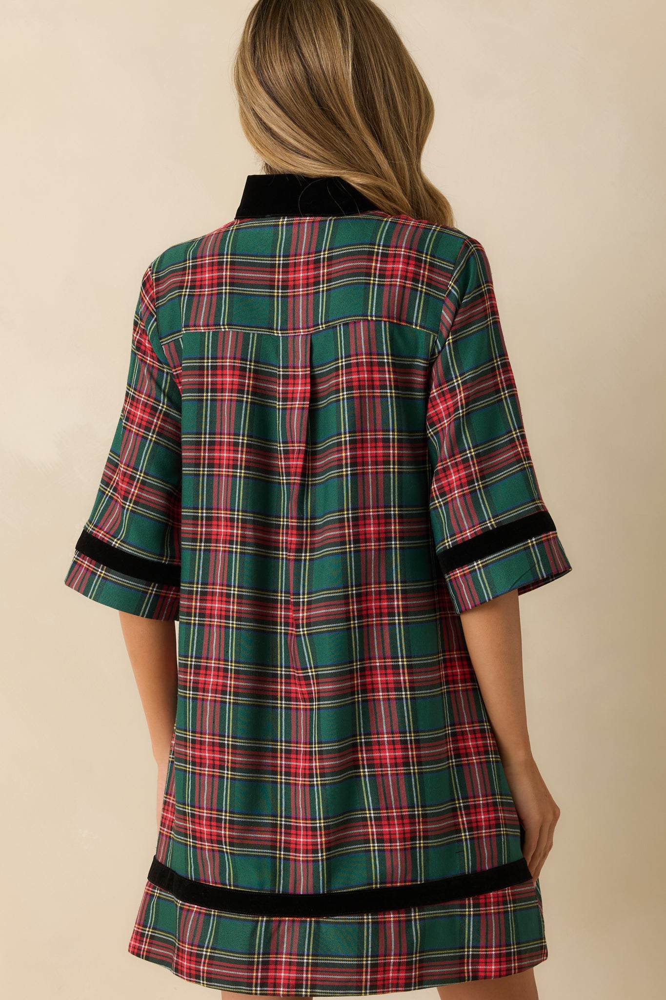 Rear view of green plaid mini dress showing elbow-length sleeves, relaxed A-line fit, and smooth lined back.