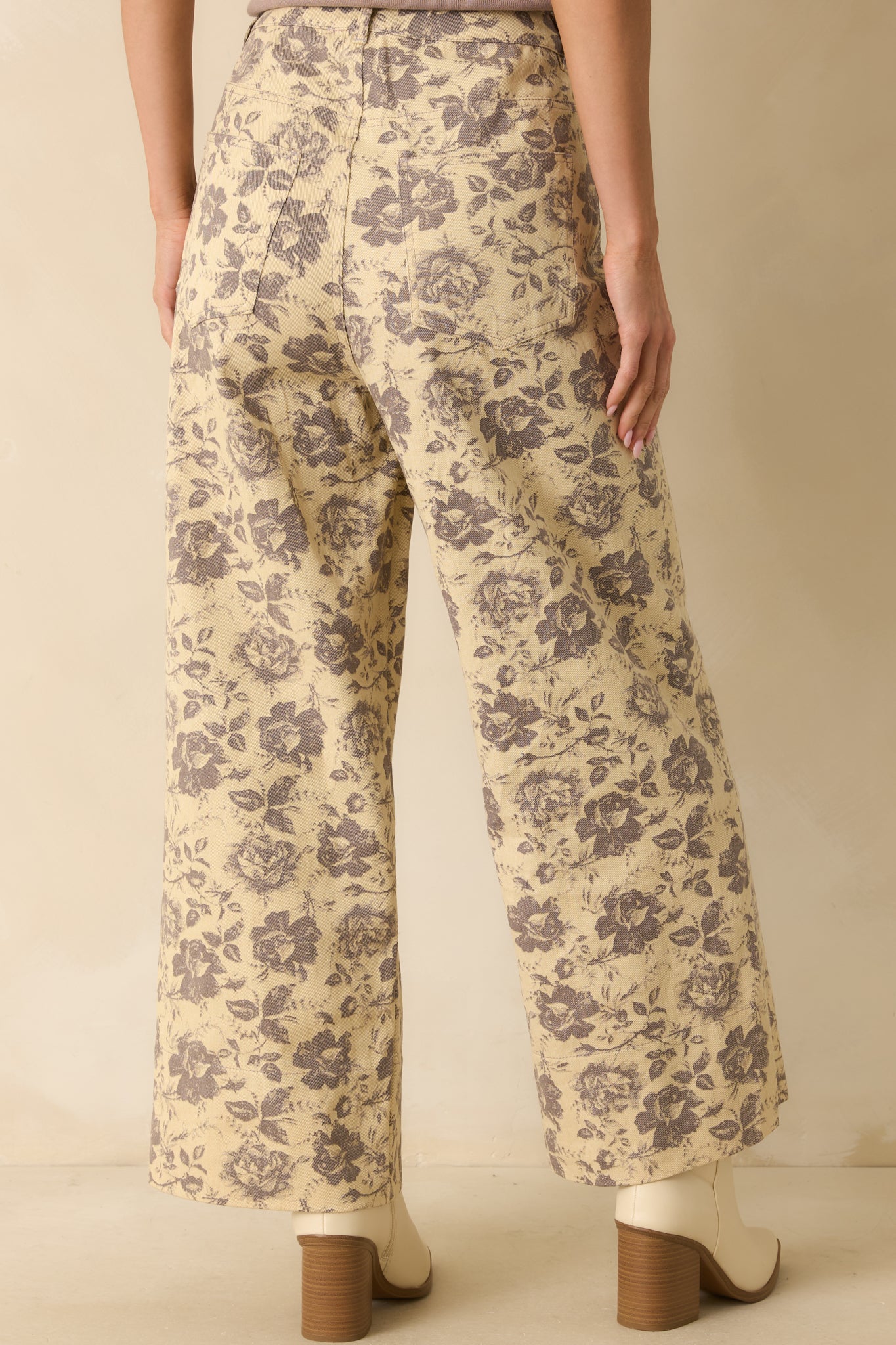 Rear view of the grey floral pants showing the wide-leg cut, high-rise fit, and continuous floral pattern.