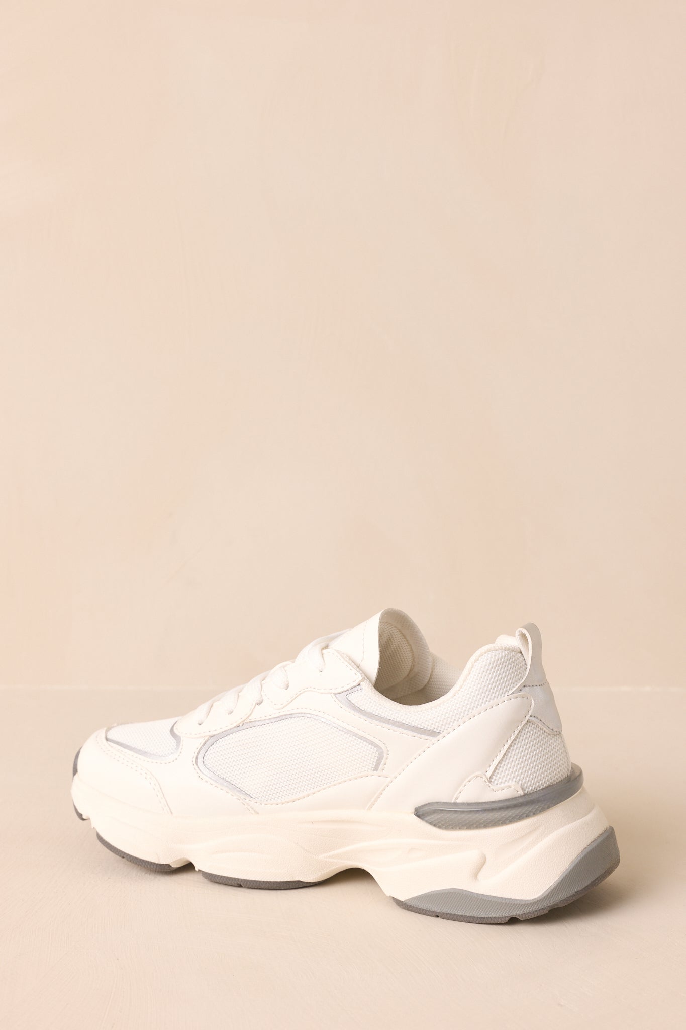 Back view of the grey and white sneakers showing heel shape, grey-accented sole, and rounded sporty design.