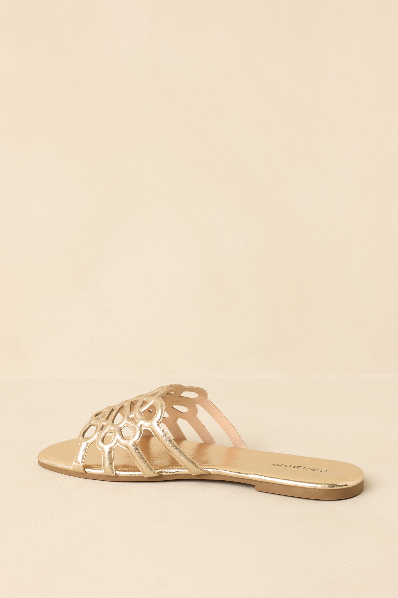 Back view of metallic gold slide sandals highlighting flat sole and minimal, clean design