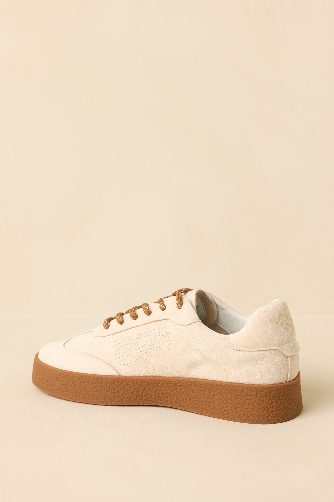Back view of natural faux suede sneakers highlighting the platform sole, heel structure, and low-profile silhouette.