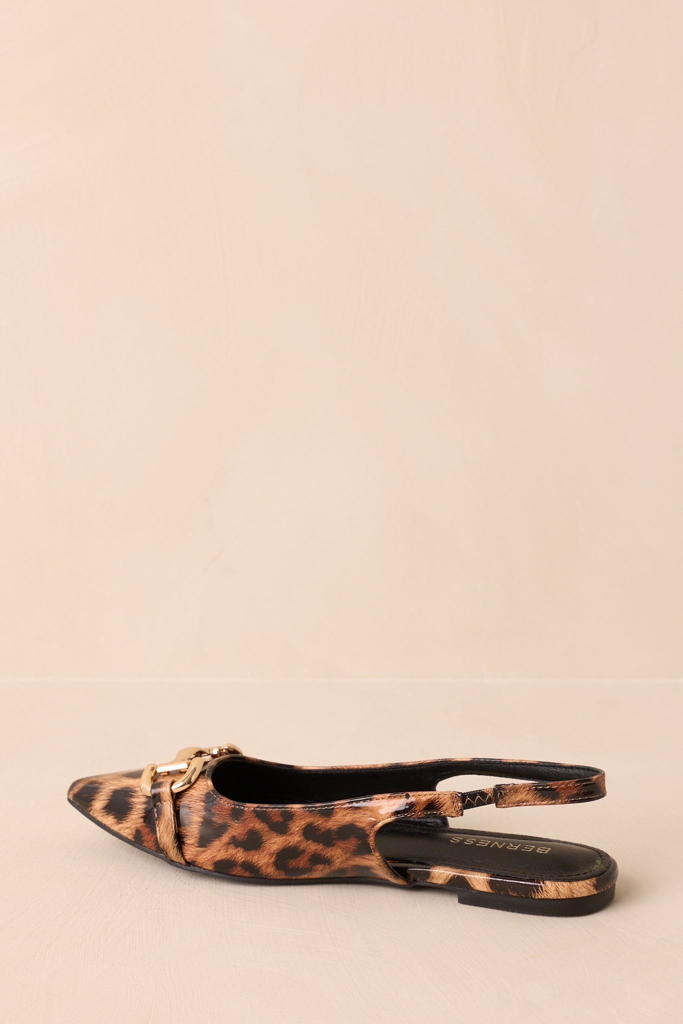 A back view of the leopard print flats highlighting the elastic slingback strap and flat sole.