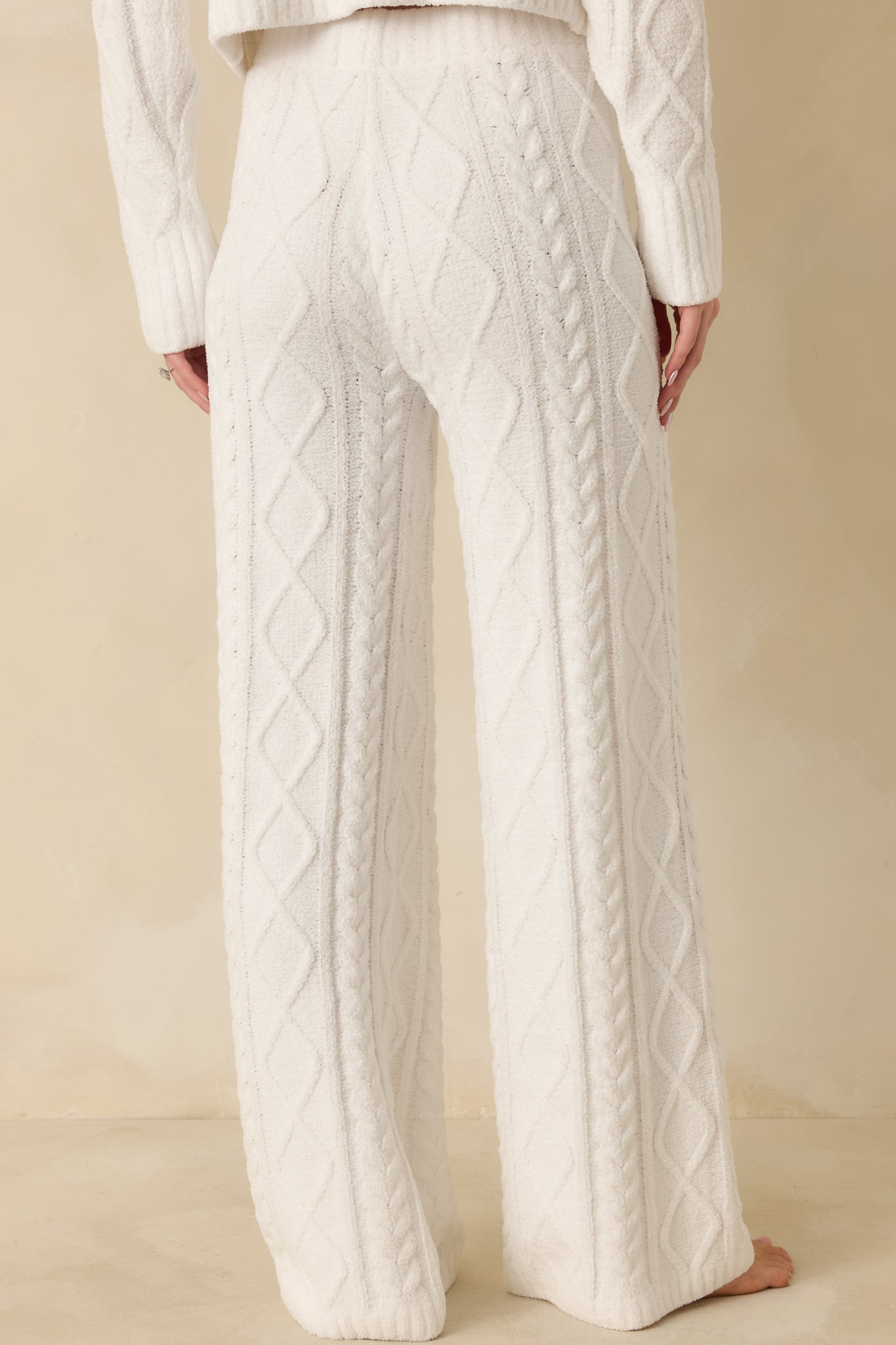 Back view of ivory cable knit pants showing wide-leg silhouette and smooth knit across the back.