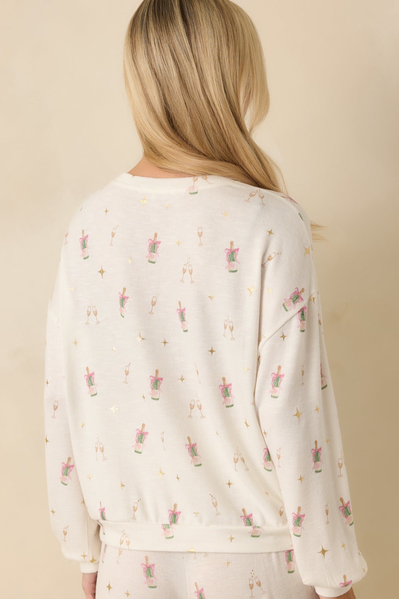 Back view of the ivory knit top showing relaxed fit and smooth back finish.