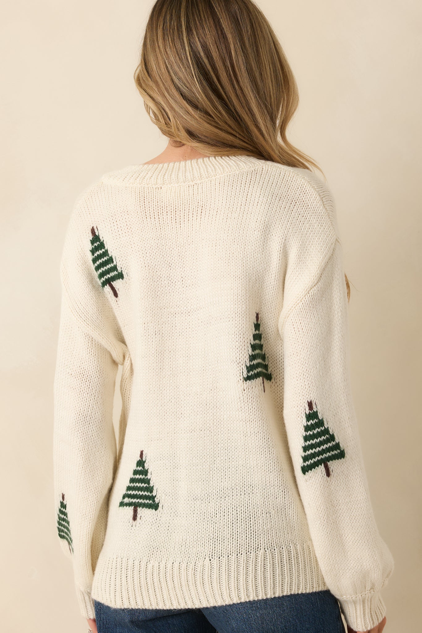 Back view of the ivory sweater showing its relaxed drape and smooth knit with slouchy sleeves.
