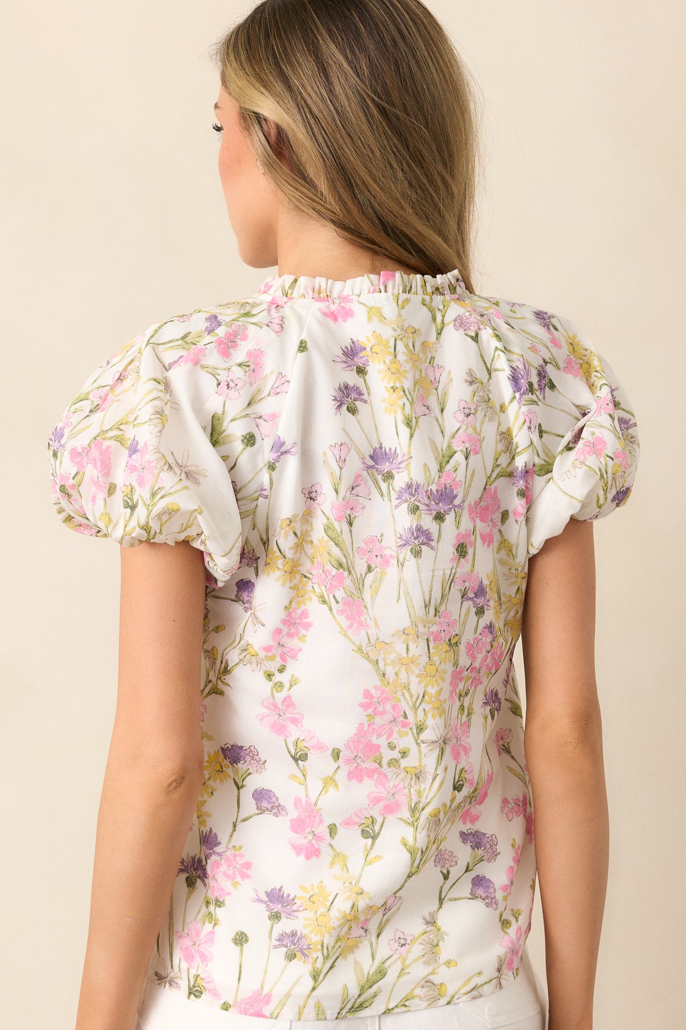 The back view of this ivory top shows the smooth fabric, with the pink floral print continuing throughout, and the button front offering a stylish, functional finish.