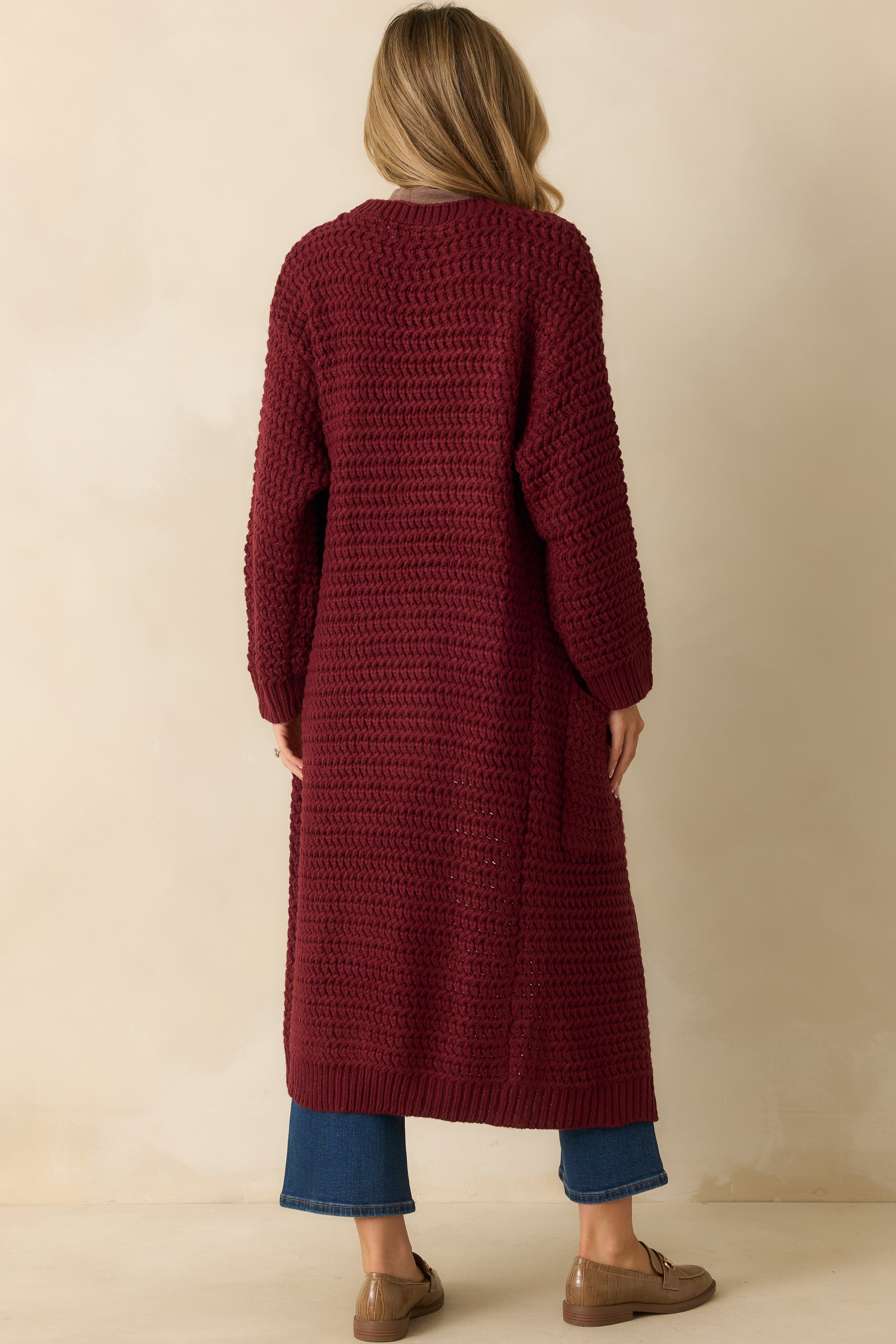 Back view showing the longline silhouette and textured knit throughout the back.