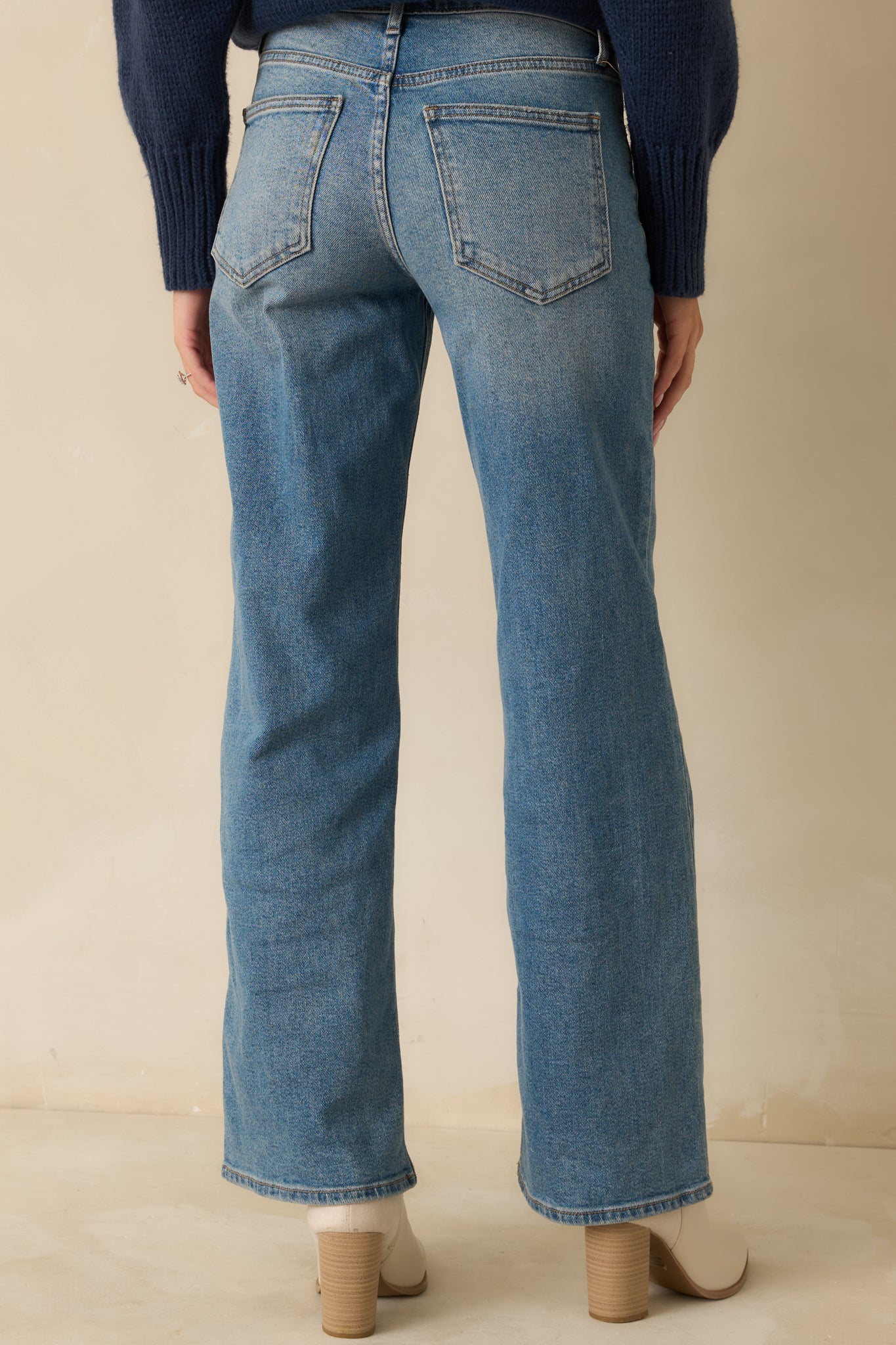 Back view of medium wash wide-leg jeans showcasing rear pockets and clean seam lines.