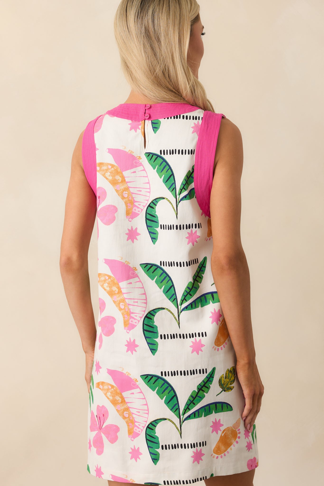 Back view of the mini dress showing the full keyhole closure, sleeveless cut, and straight shape of the shift silhouette with pink accents.