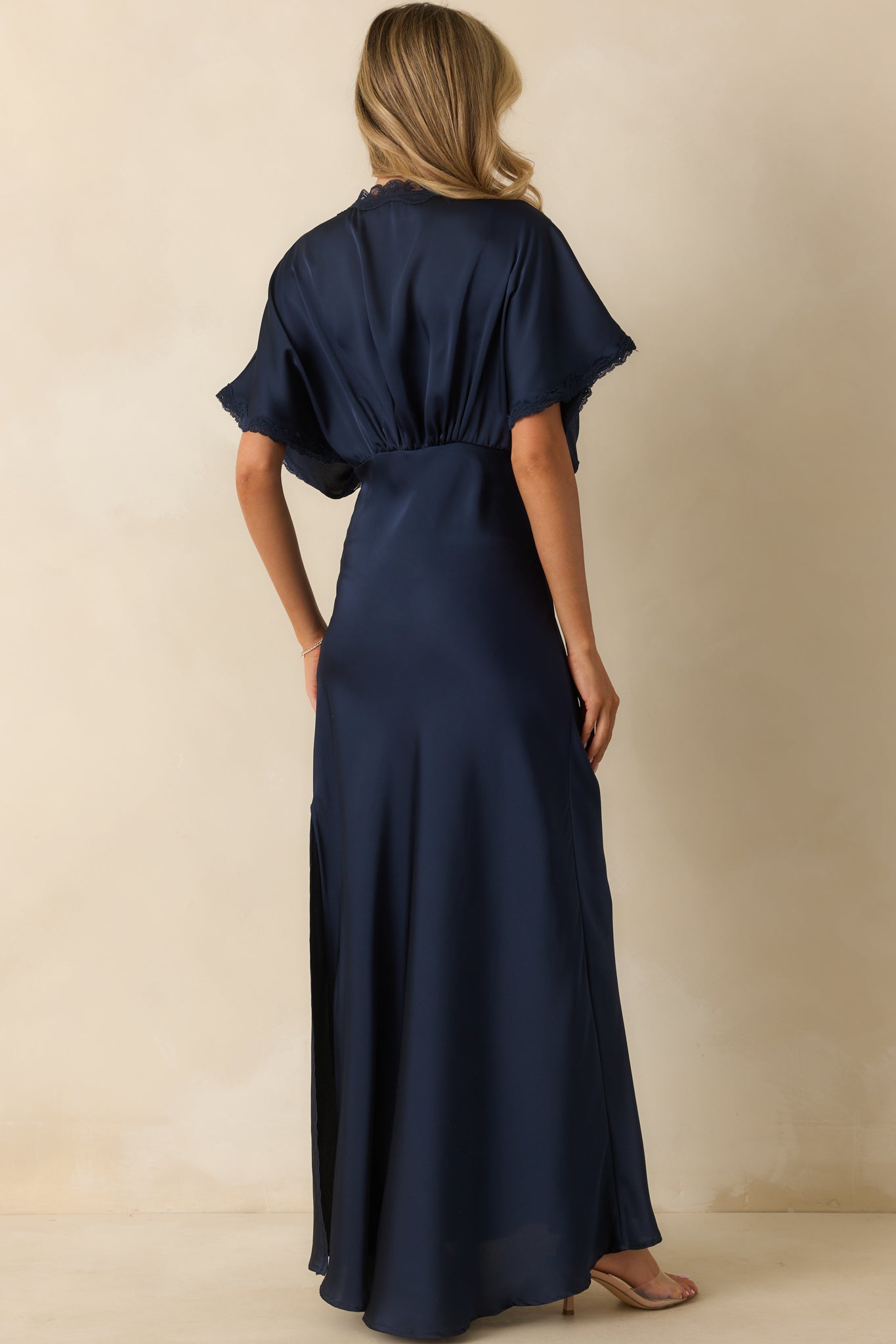 Rear view of the navy satin maxi dress highlighting the hidden side zipper and clean back design.