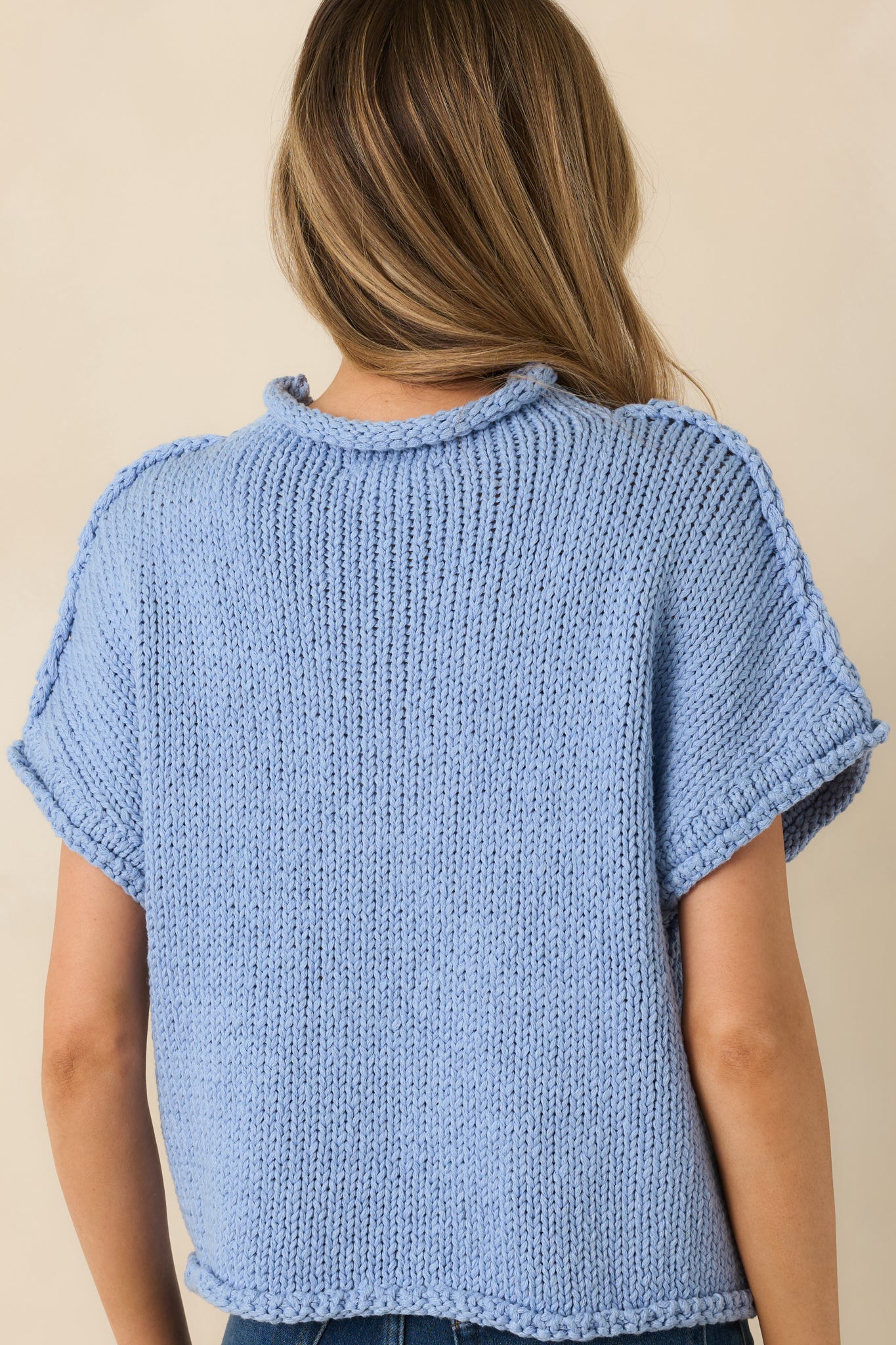 Light blue chunky knit sweater, crew neckline, short sleeves, rolled-edge details at neckline, sleeves, and hem.