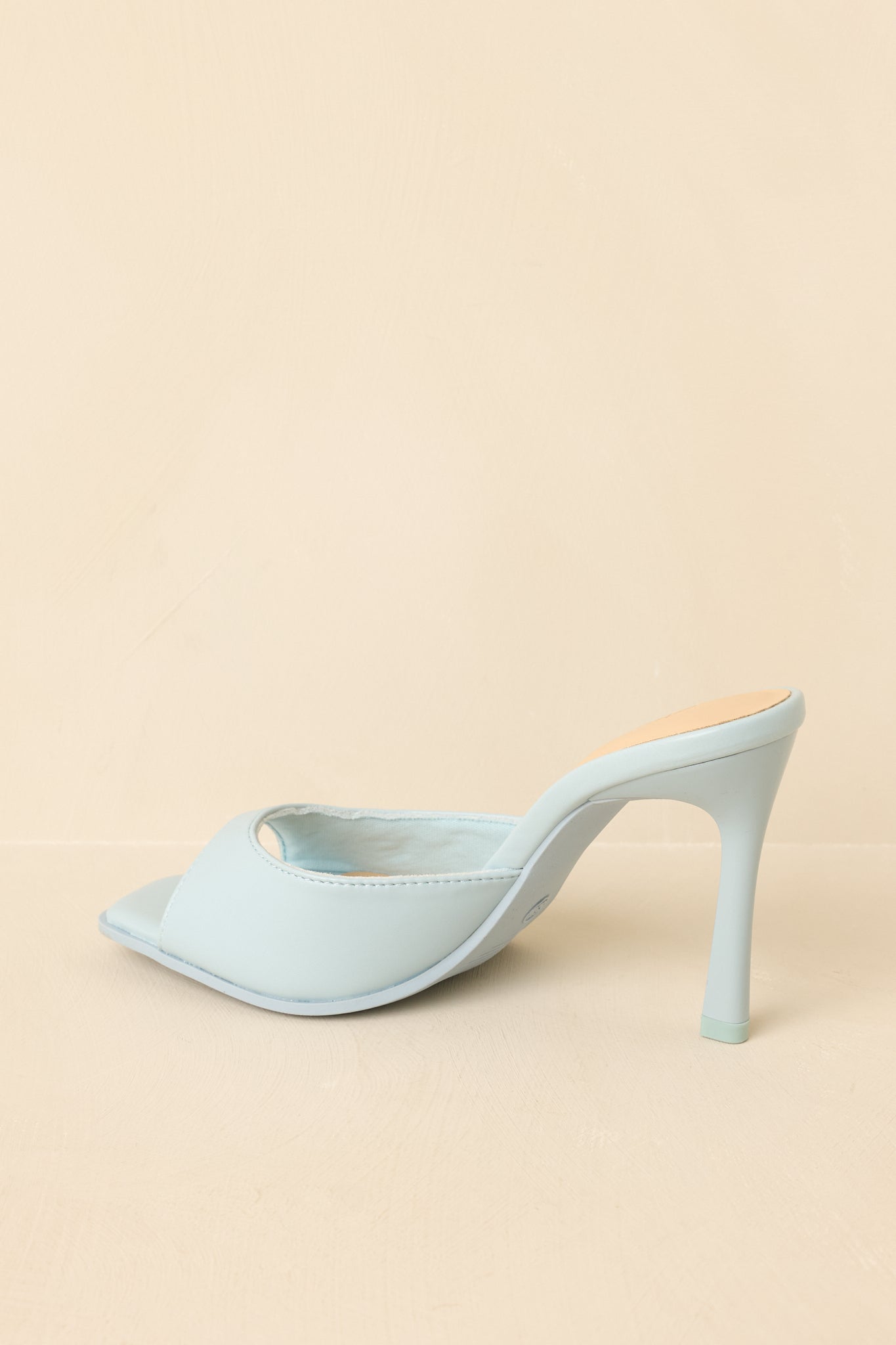 Back view of blue mule heels showing open heel and slim high heel design.