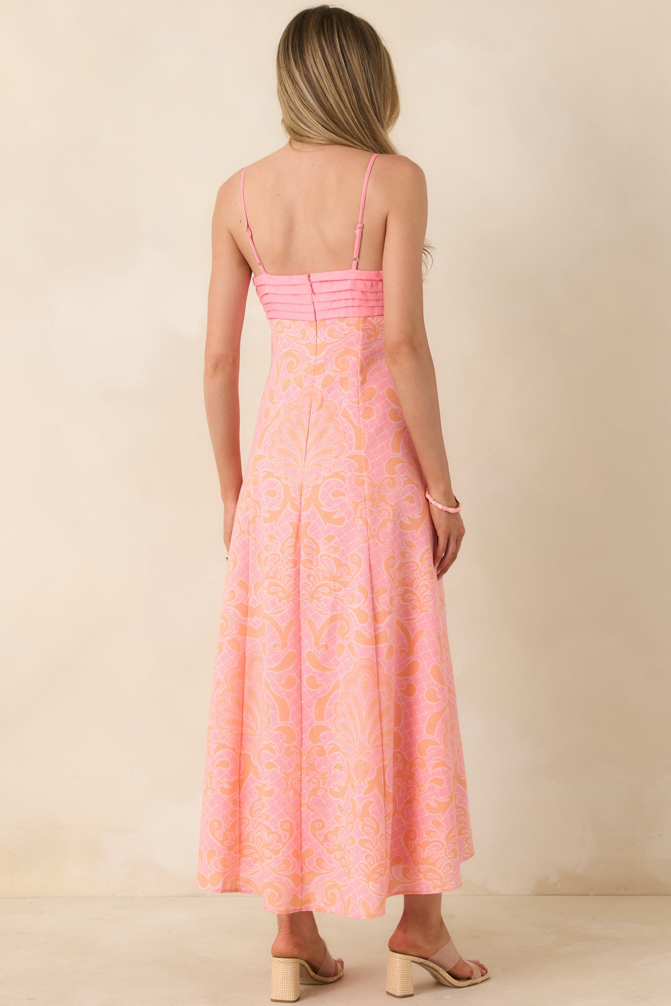 Back view of pink and orange midi dress featuring adjustable spaghetti straps and a concealed zipper closure