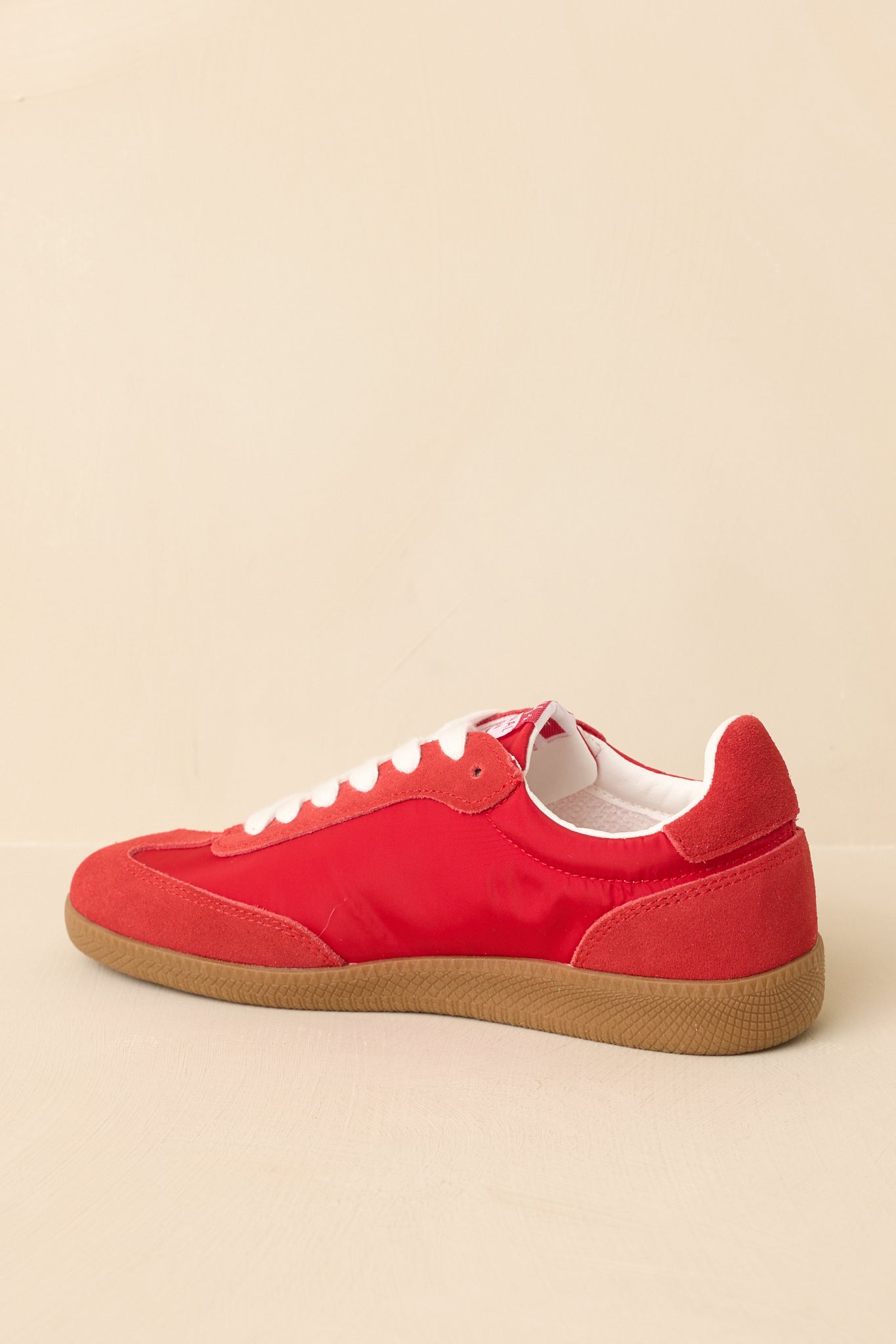 Back view of red sneakers showing heel tab, textured finish, and traction outsole.