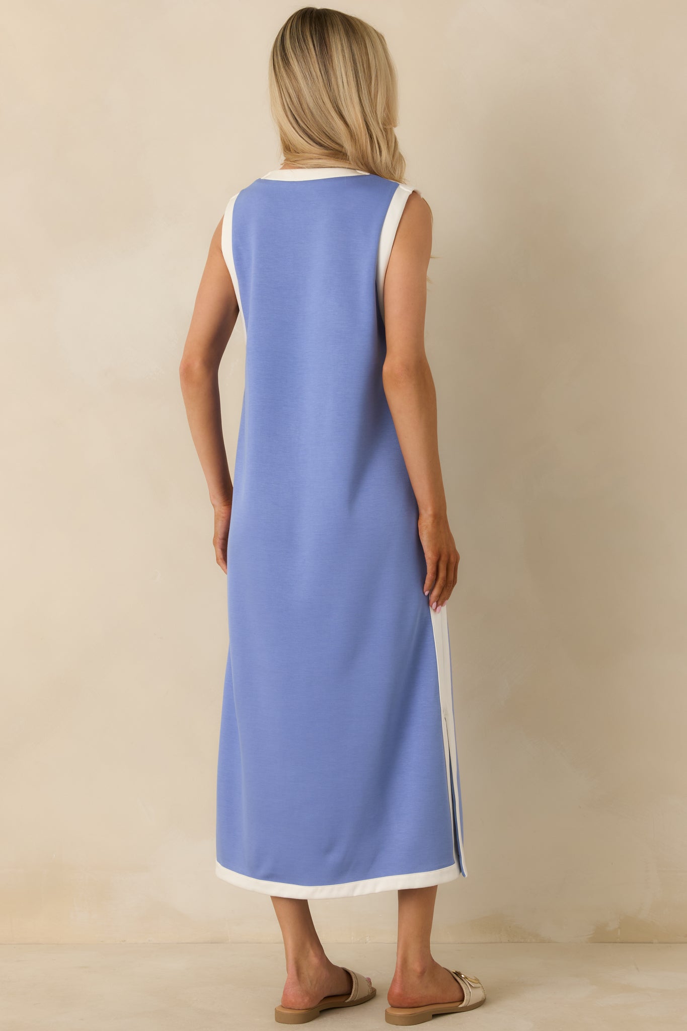 Back view of the blue sleeveless maxi dress highlighting the straight silhouette, contrast-trimmed side seams, and full-length hem.