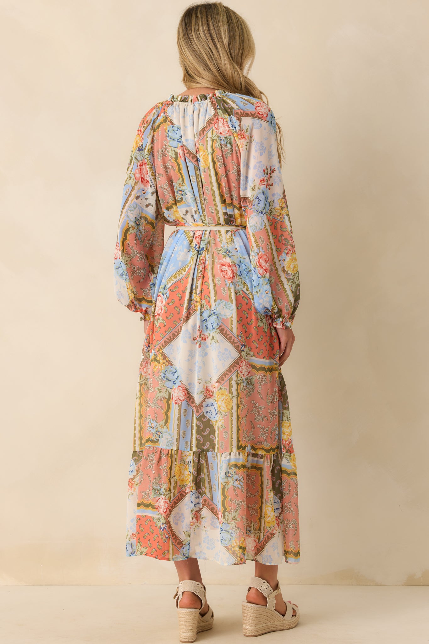 Back view of the dress showing the belt loops, ruffled collar continuing, and floral print fabric.