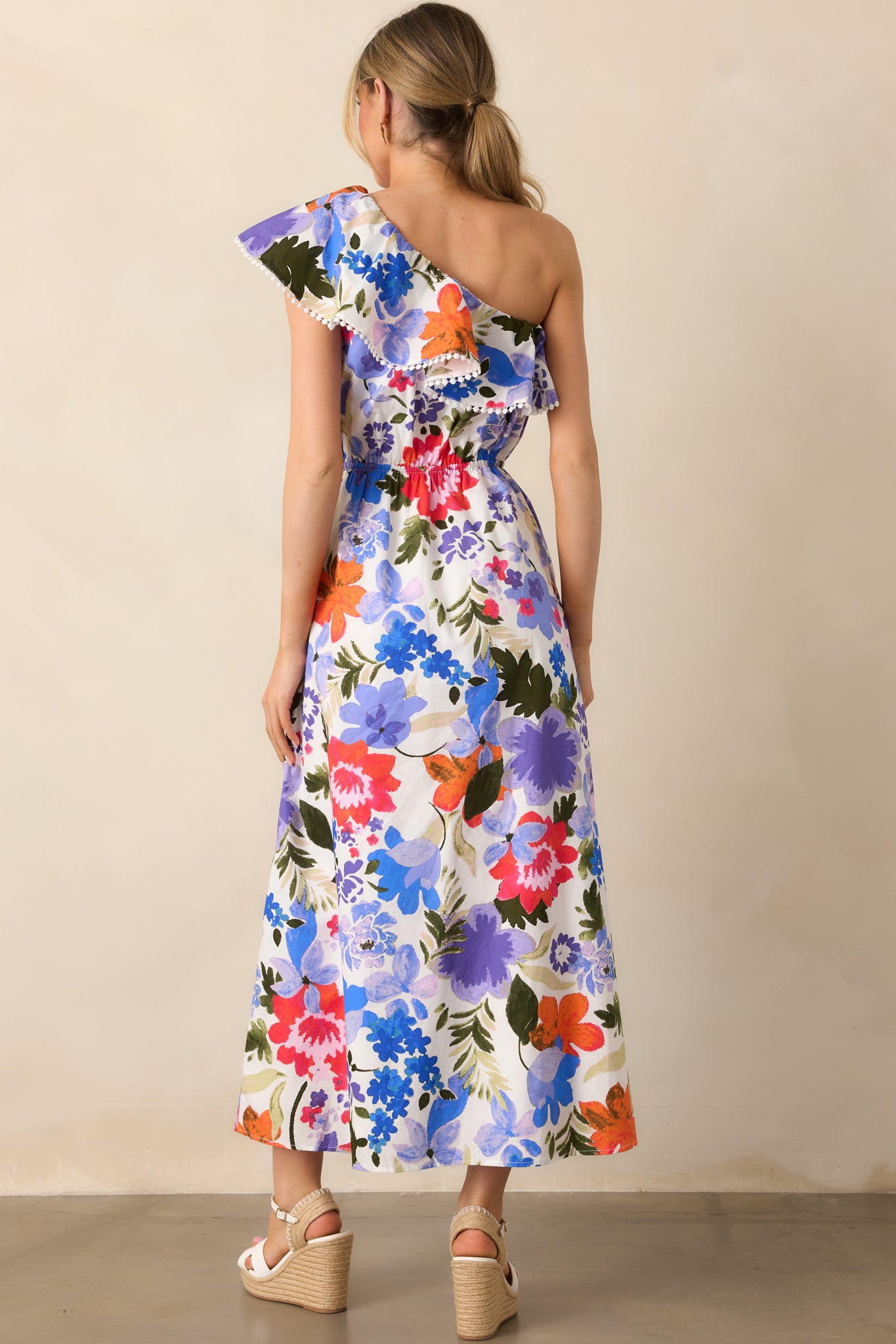 The back view of the maxi dress, focusing on the simple, clean design with the elastic waist and the flowy nature of the fabric that complements the floral pattern.