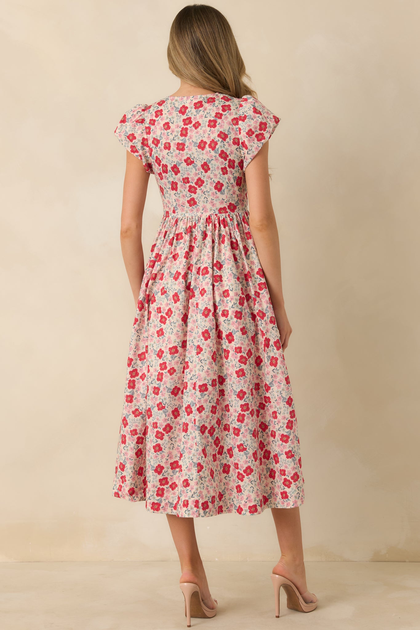 Back view of the floral midi dress showing the smocked bodice and flowing gathered skirt.