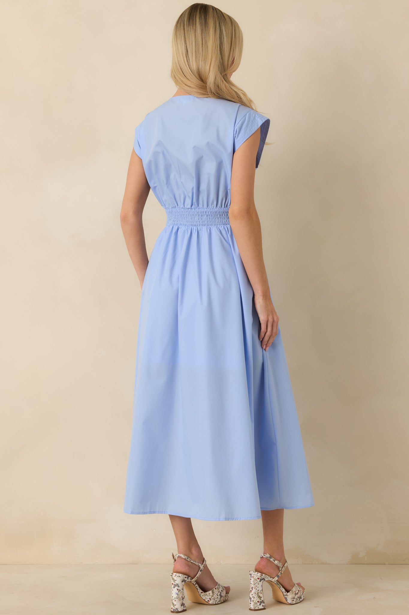 Back view of the light blue sleeveless midi dress highlighting the smooth back panel and gently gathered skirt.
