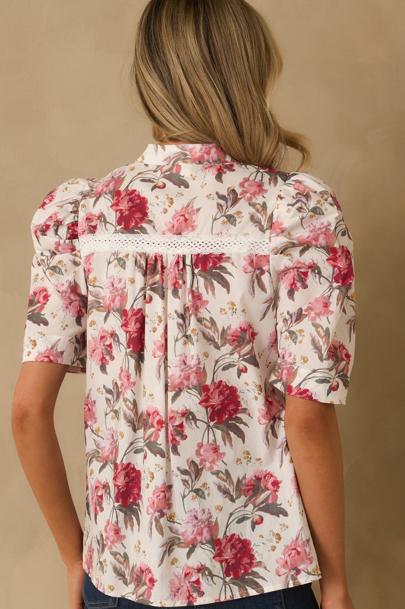 A back view of the pink multicolor floral top highlighting its overall print and puff sleeve silhouette.