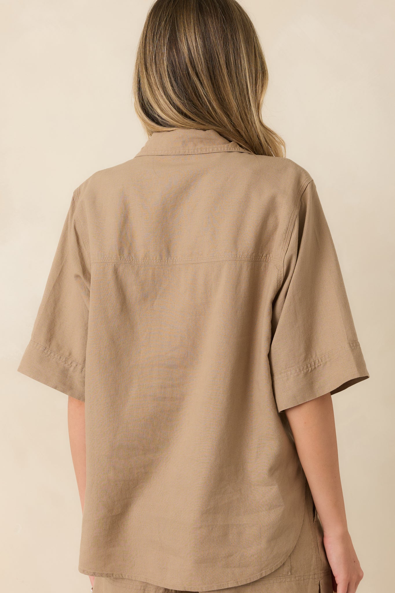 Back view of the taro brown button-up top featuring elbow-length sleeves, a relaxed fit, and a curved shirttail hem.