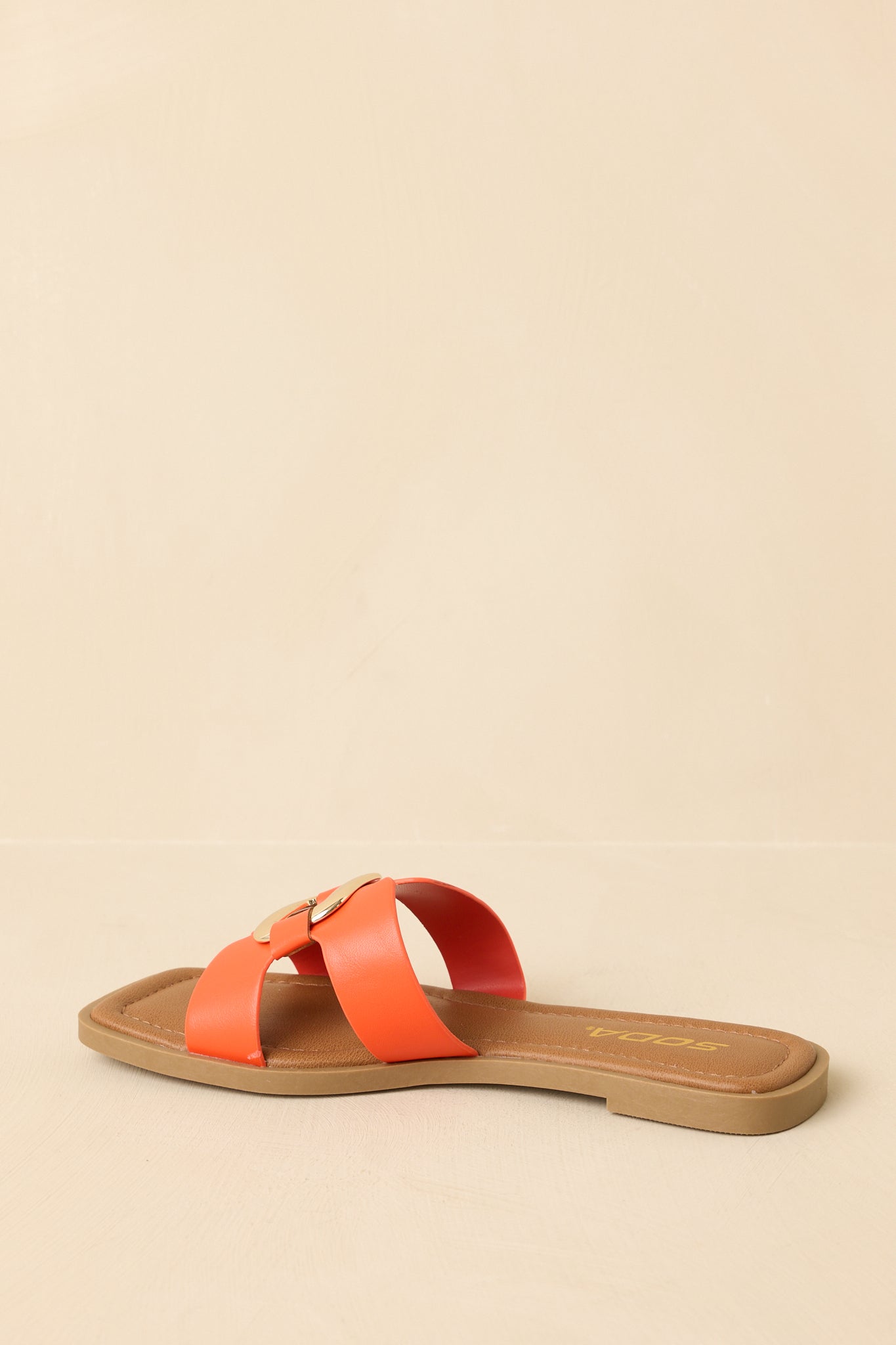 Back view of the orange flat slide sandals showing the back of the footbed and flat sole construction.