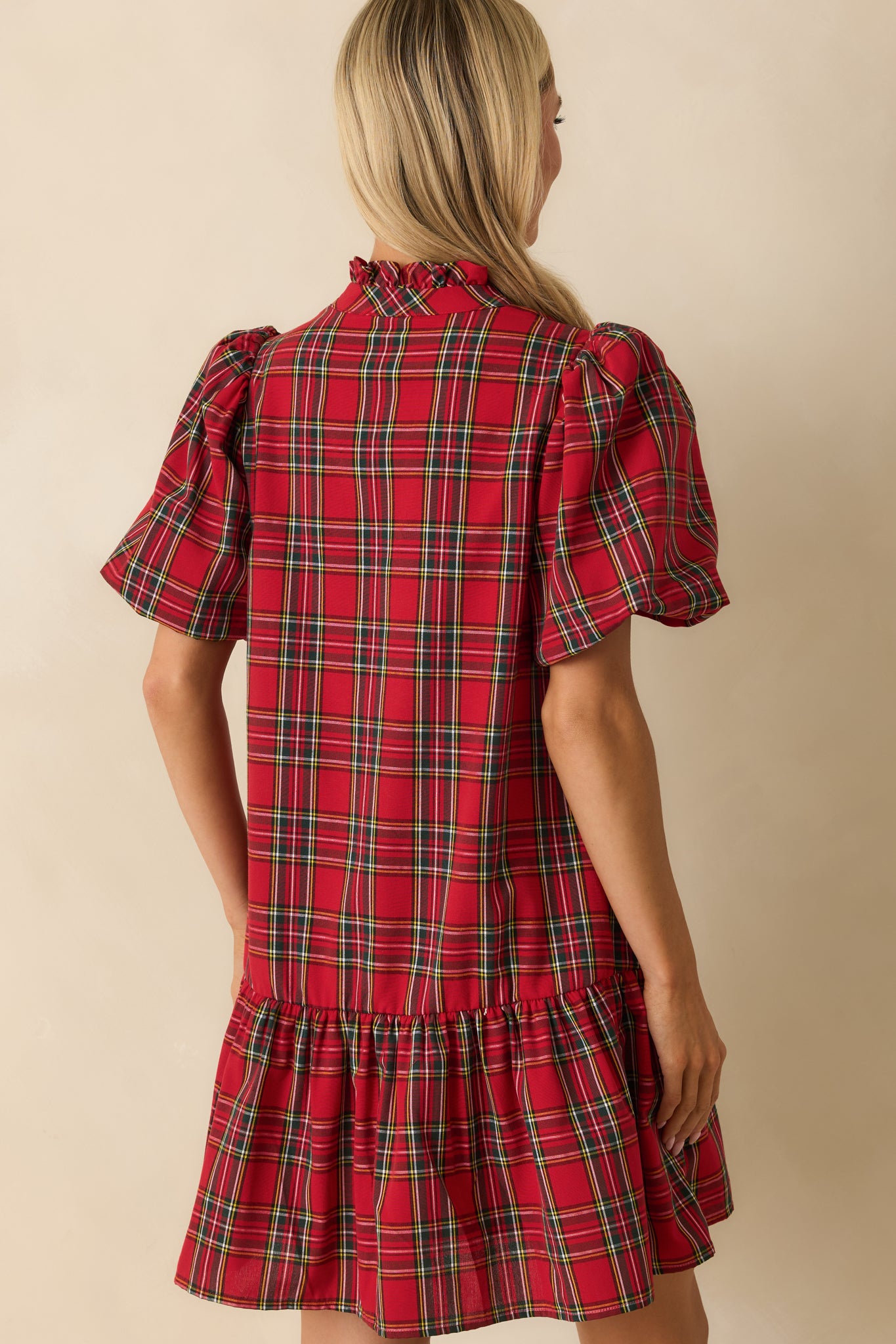 Rear view of red plaid mini dress showing short puff sleeves, relaxed fit, and fully lined woven back.