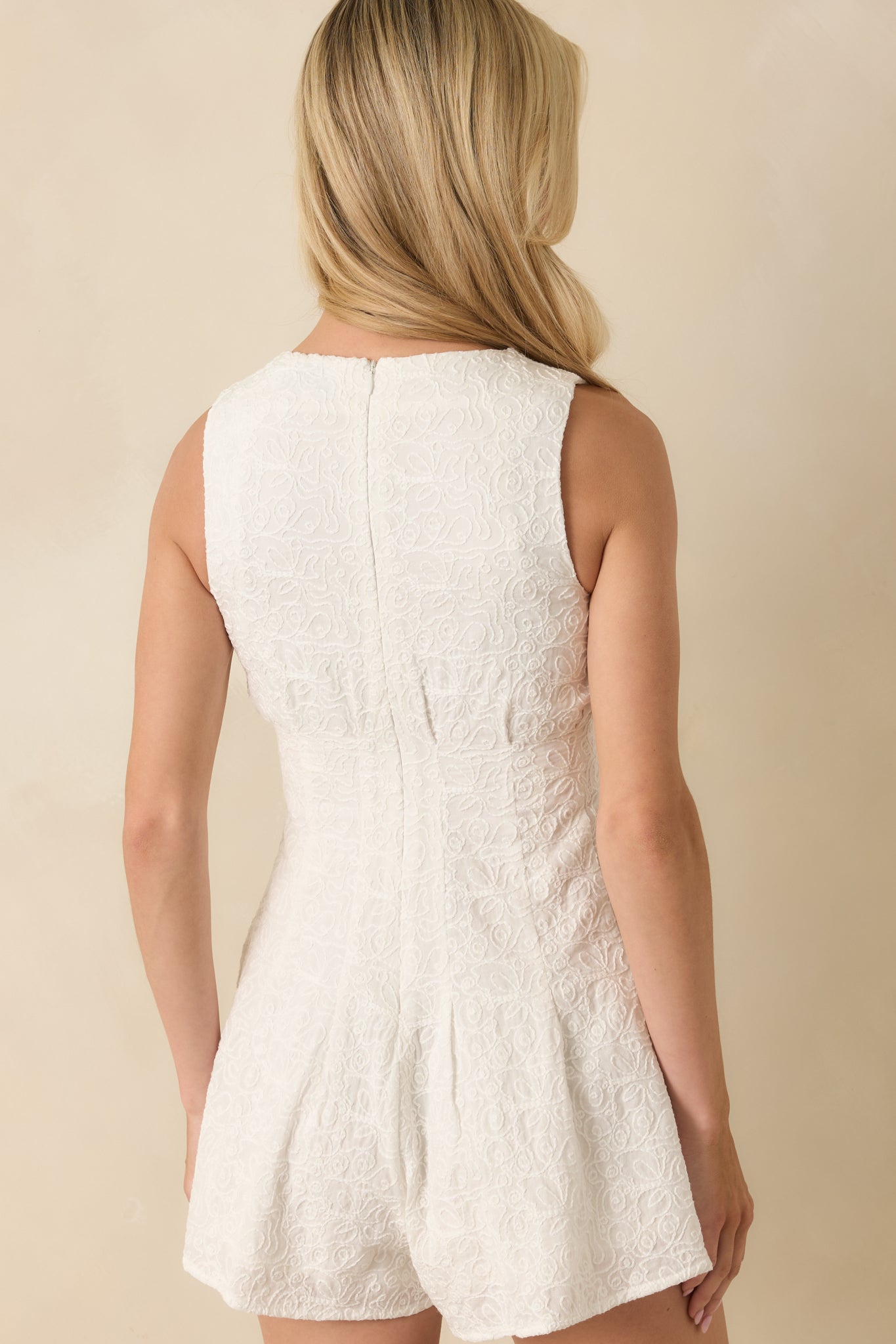 Back view of the romper highlighting the hidden zipper and clean embroidered finish.