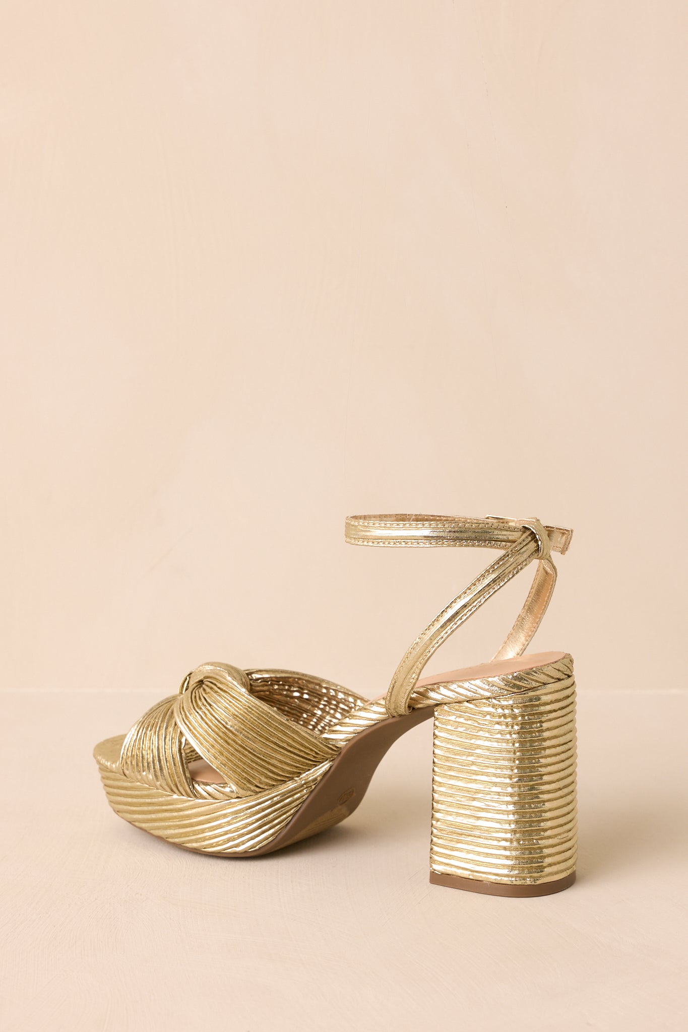 A back view of the sandals showing the block heel, ankle strap with buckle closure, and platform sole.