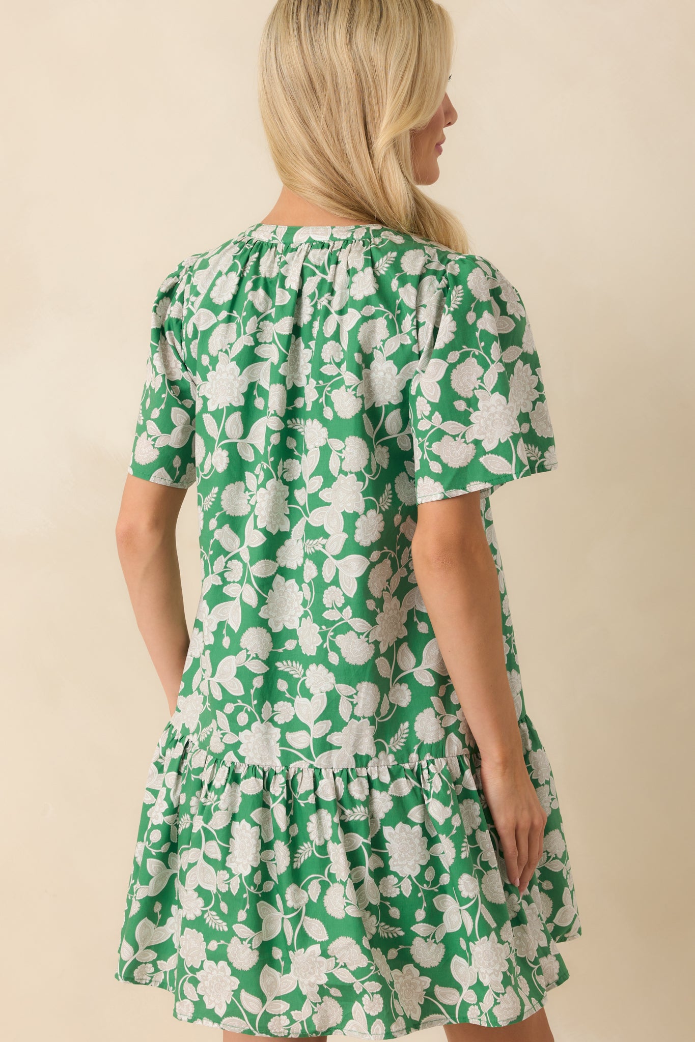 Back view of the mini dress showing the continuation of the tiered skirt, short sleeves, and the loose, relaxed silhouette from behind.