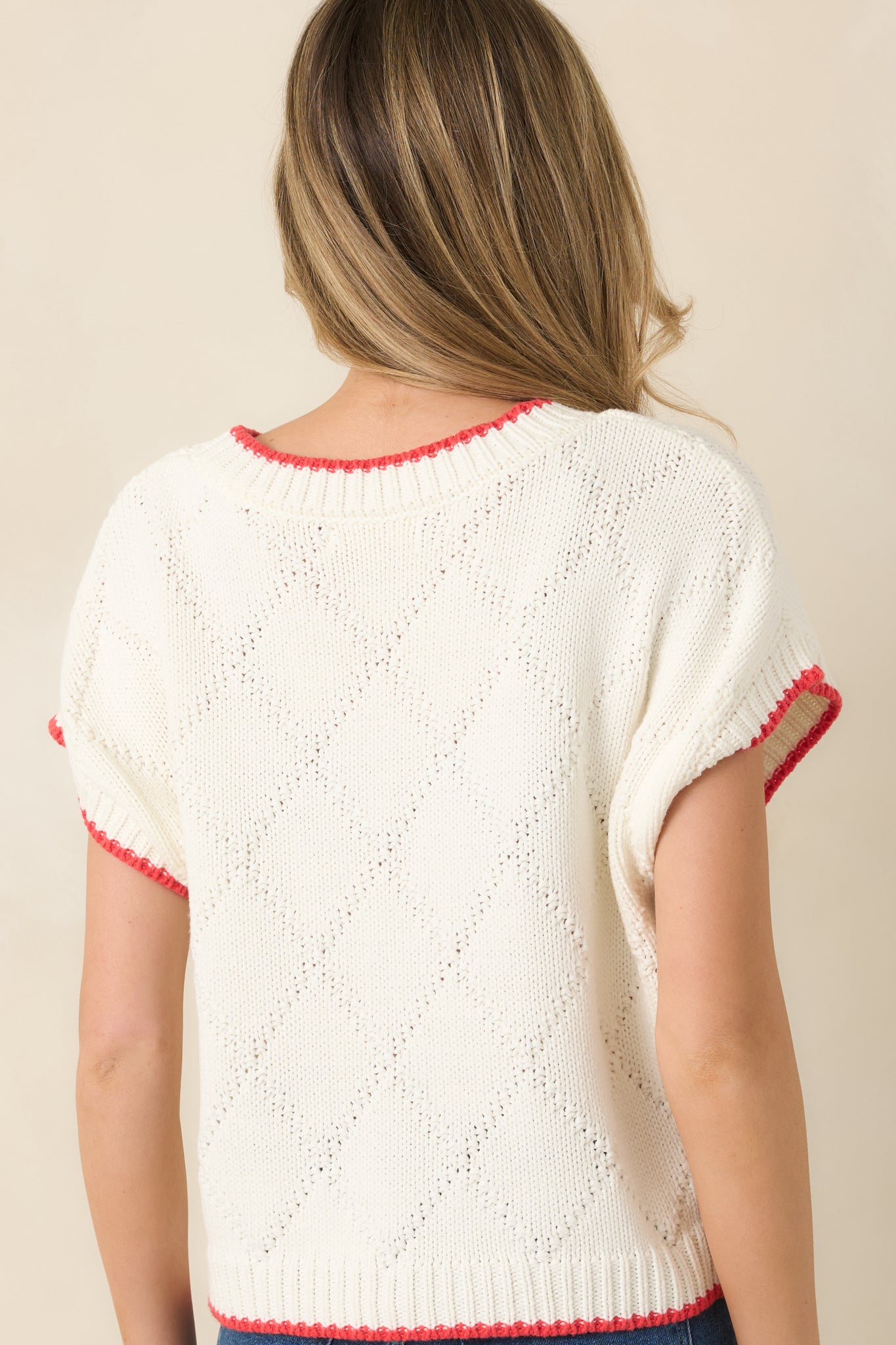Back view of the ivory short-sleeve knit sweater showing the clean, textured knit with ribbed hem and cuffs.