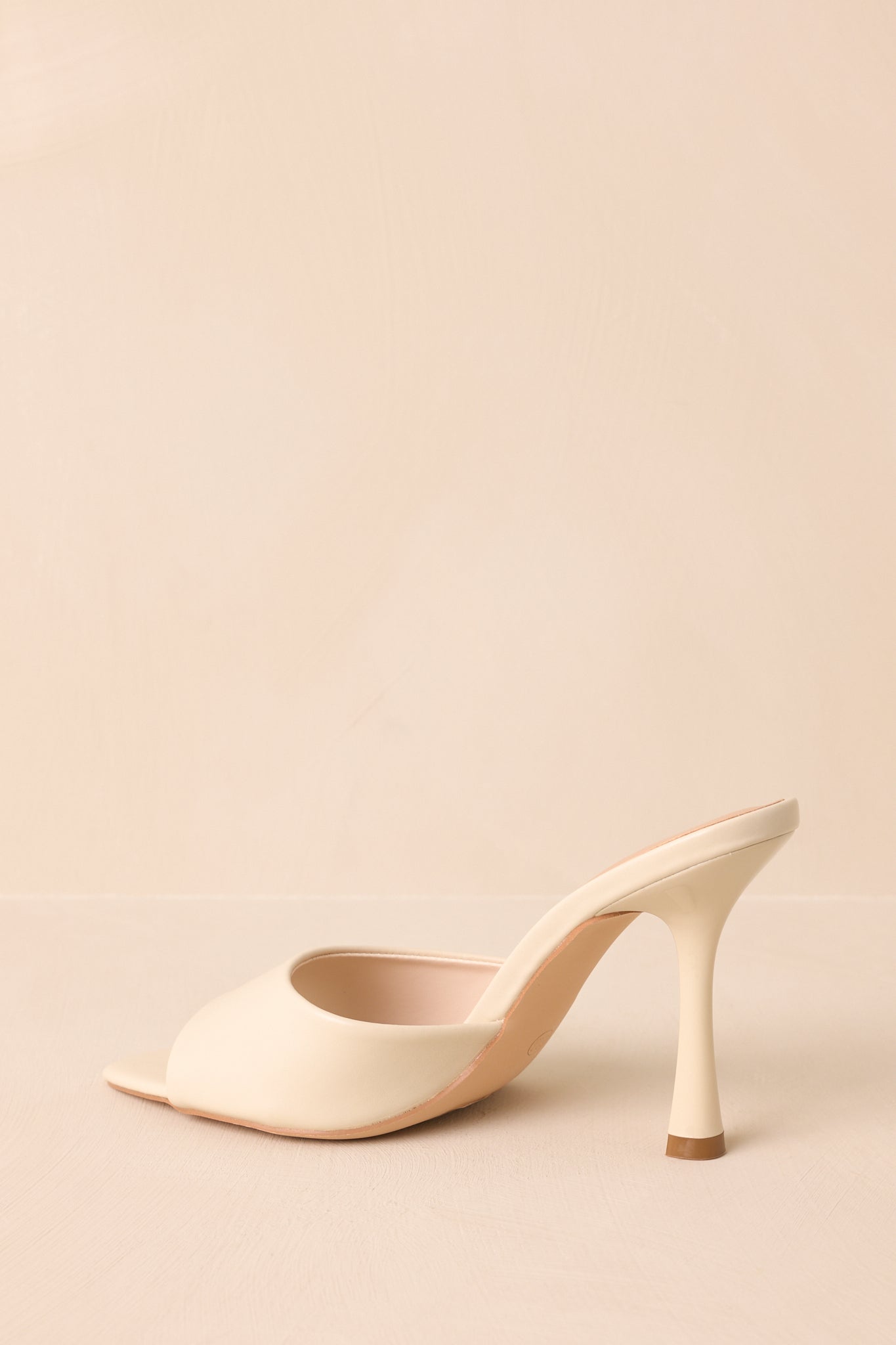 Back view showing the slender stiletto heel and clean faux leather finish.