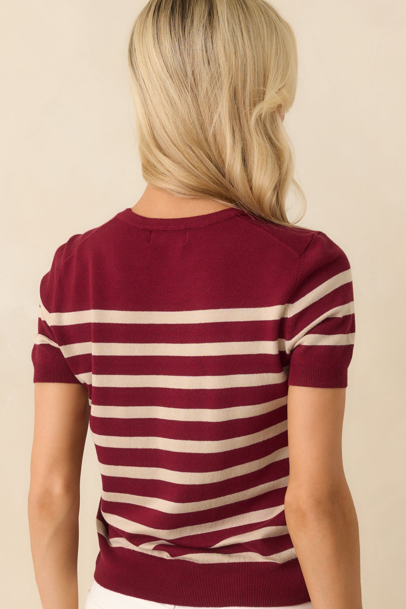 Back view of the sweater showing the continuation of the stripe print and ribbed edging at the hem and sleeves.