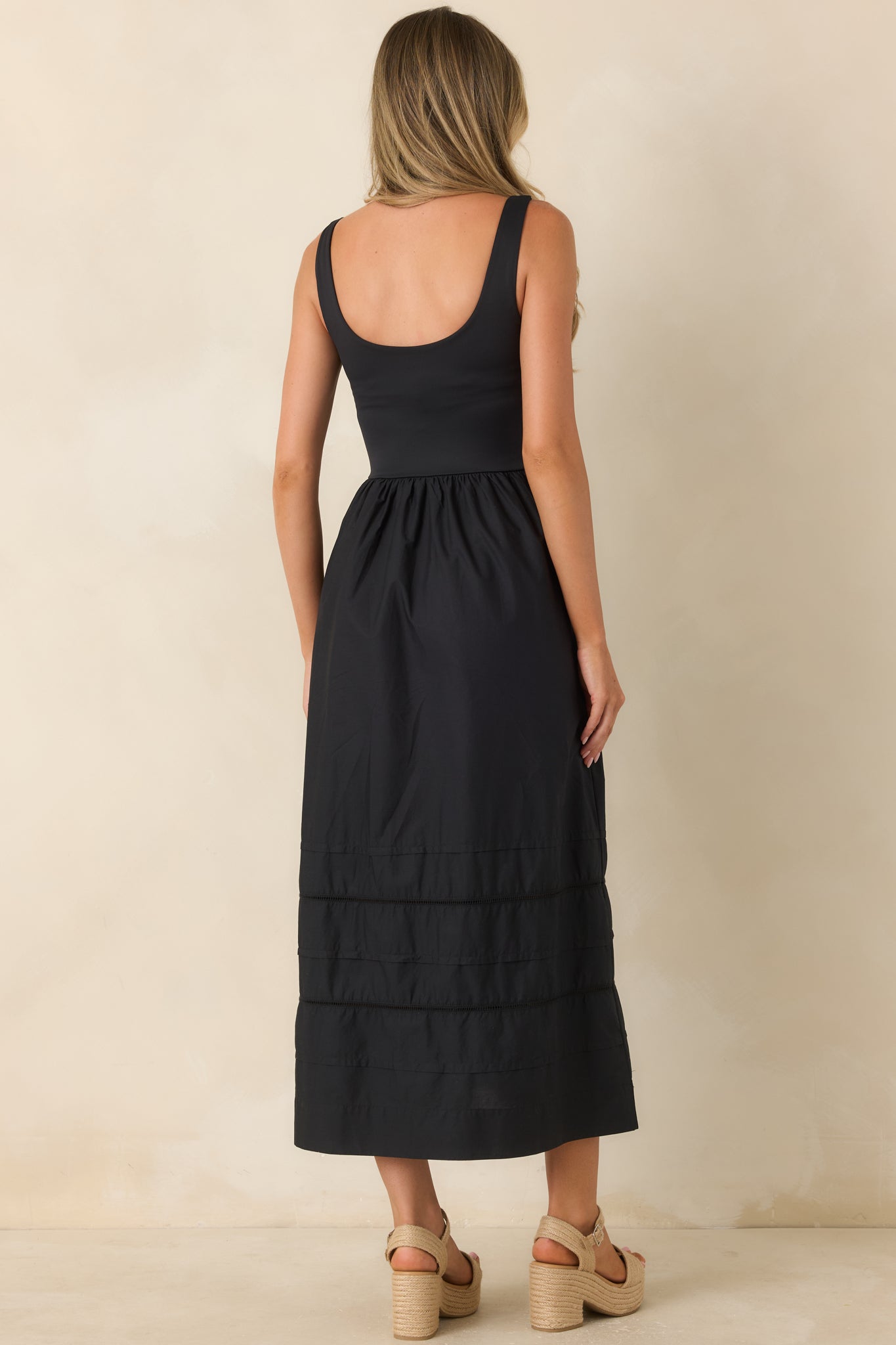 Back view of the sleeveless midi dress highlighting the fitted bodice and flowing skirt silhouette.