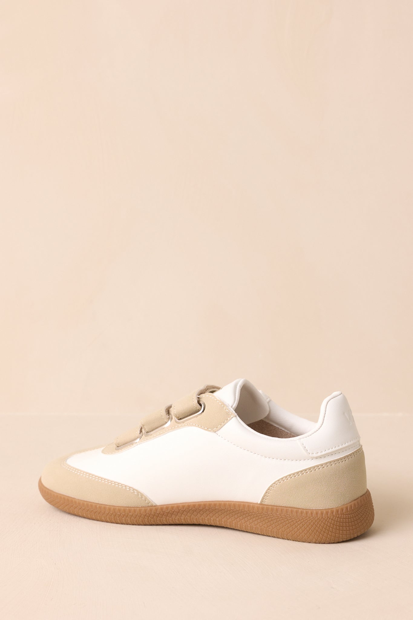Back view of the sneakers showing the heel shape, brown rubber outsole, and beige suede accents.