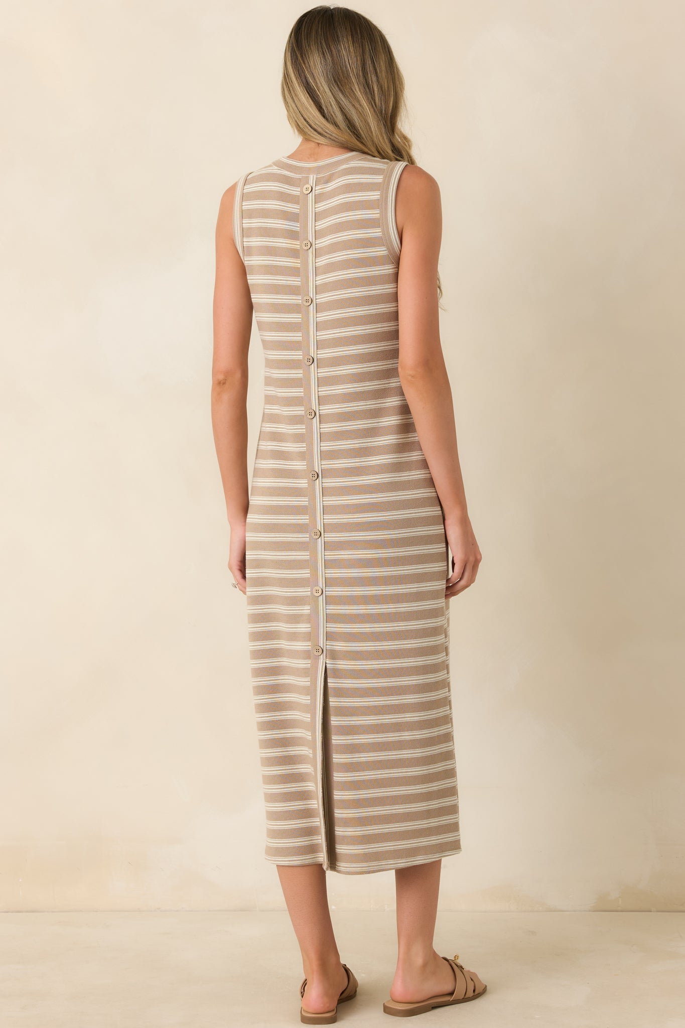 Back view of the taupe stripe midi dress featuring a faux full-length button placket and partial hem slit.