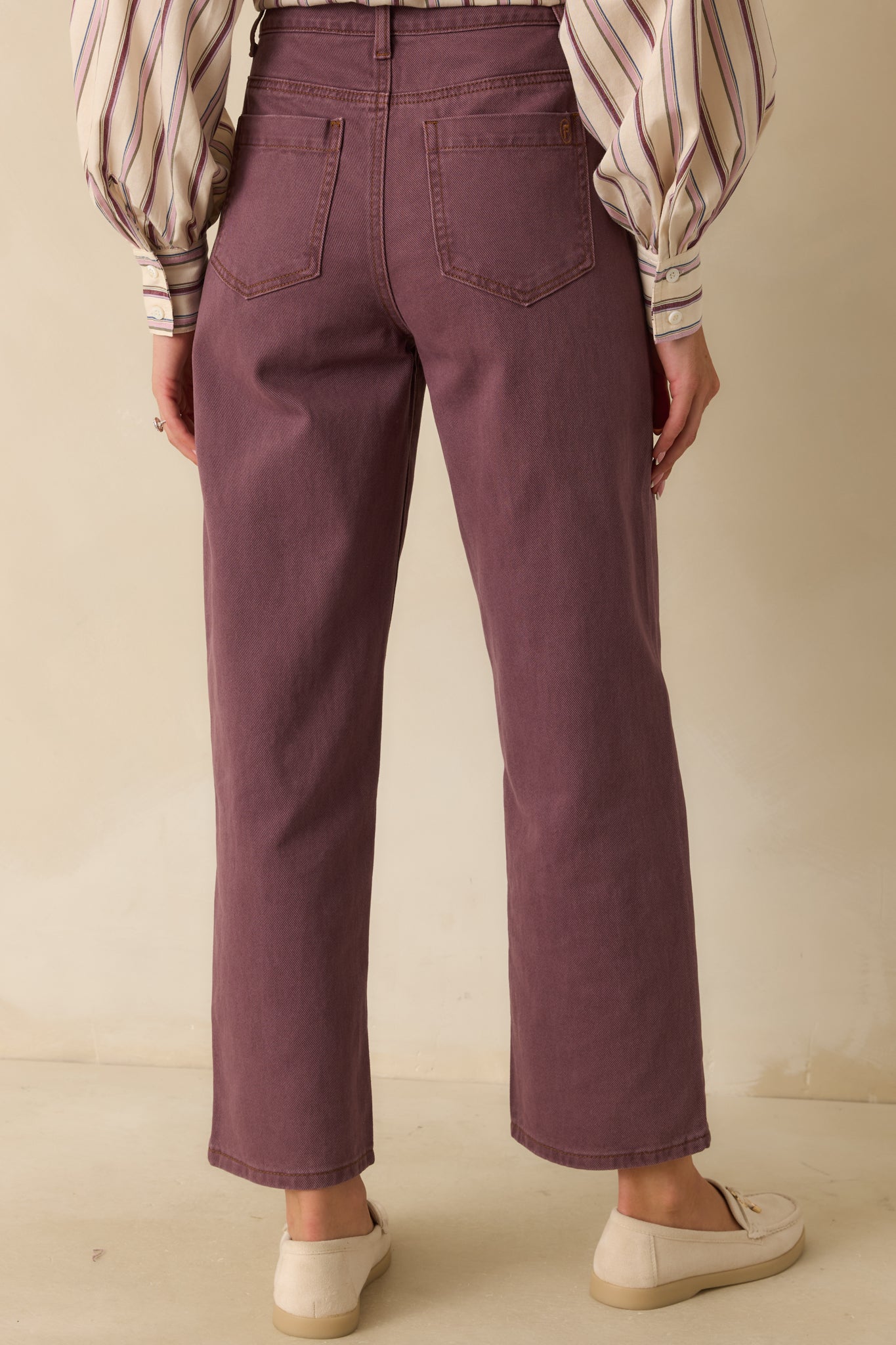 Rear view of the violet jeans showing functional back pockets, structured silhouette, and straight-leg shape.