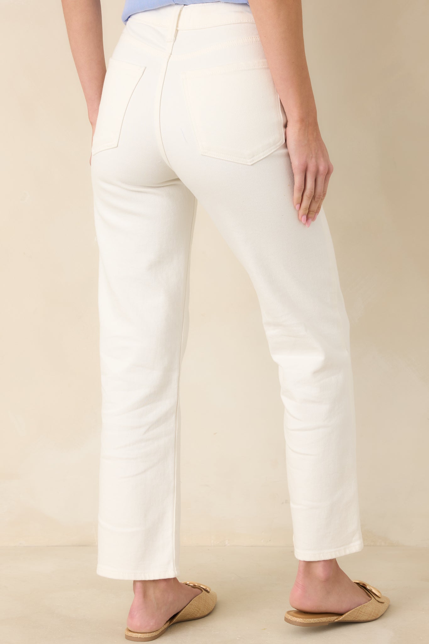 Back view of white high-waisted jeans highlighting the rear pockets and structured waistband.