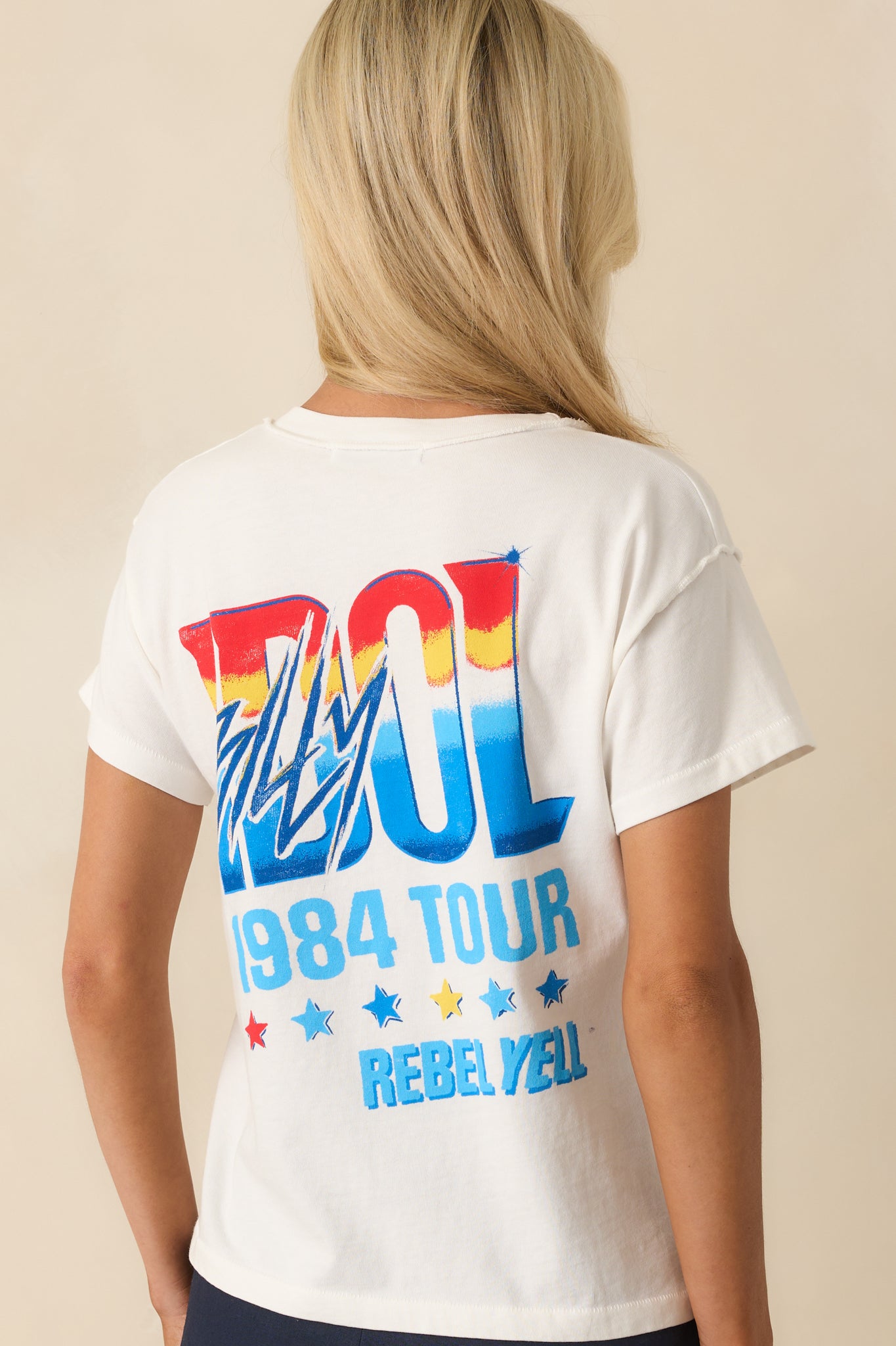 Back view of the tee highlighting the plain white fabric and visible reverse seams running vertically and across the shoulders.