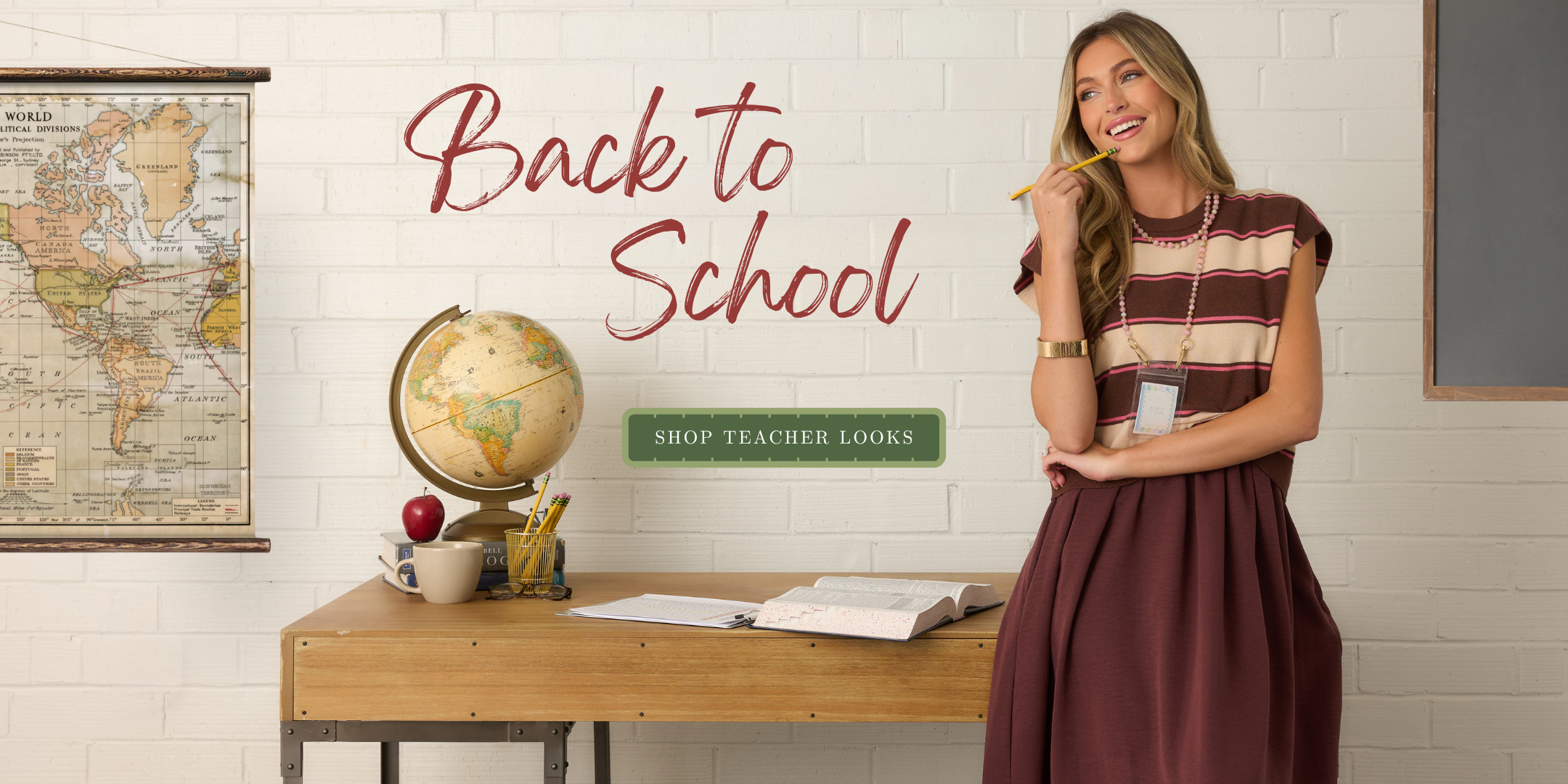 A woman in a school-themed setting with a desk, globe, and map, wearing a striped cap-sleeve top and a dark maroon skirt. Large text reads 'Back to School' with a 'Shop Teacher Looks' banner.
