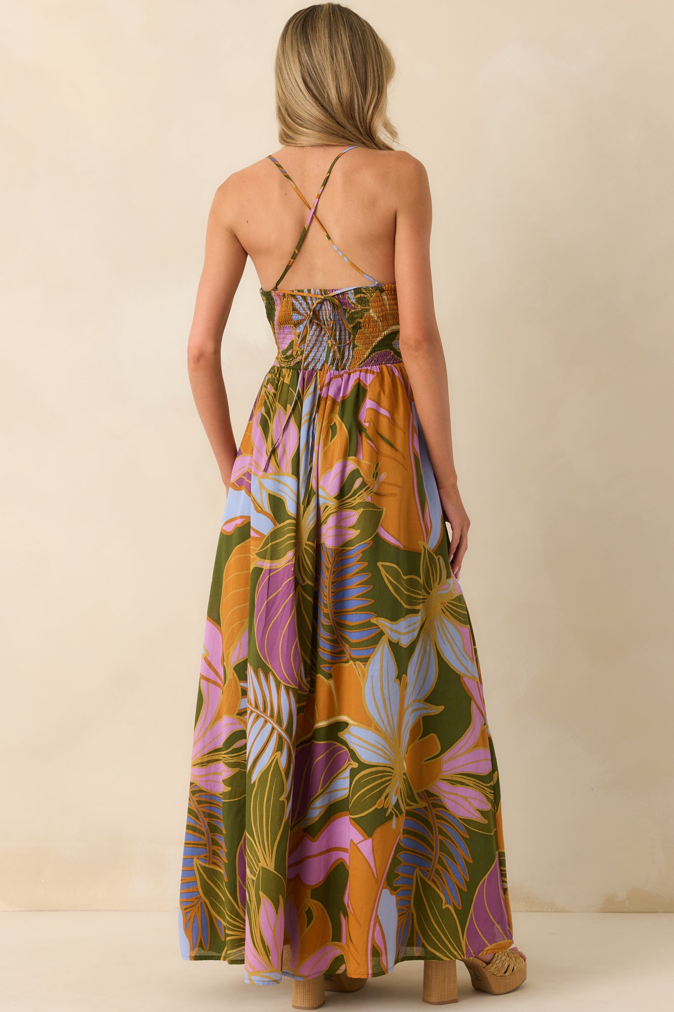 A view from behind showing the criss cross open back, adjustable straps, and smocked back panel of the maxi dress.