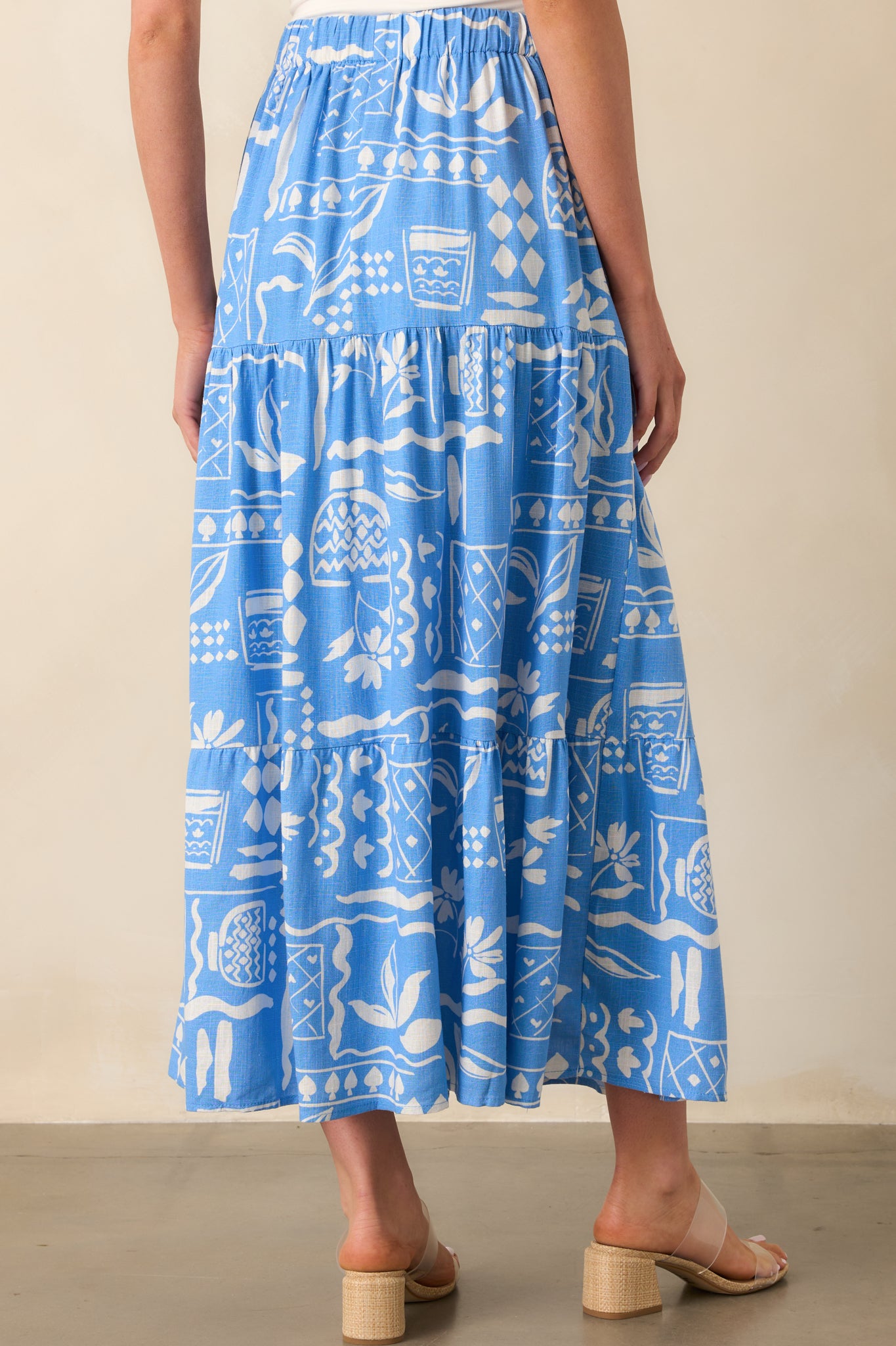 A view from behind showing the elastic waistband and full tiered flow of the printed maxi skirt.