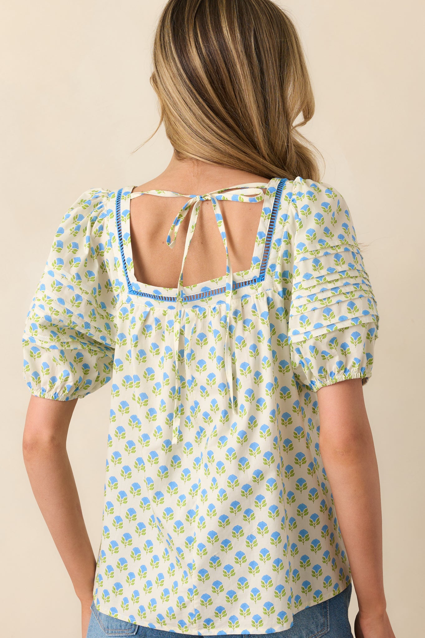 A view from behind showing the self-tie closure and gathered fit of the floral cotton top.