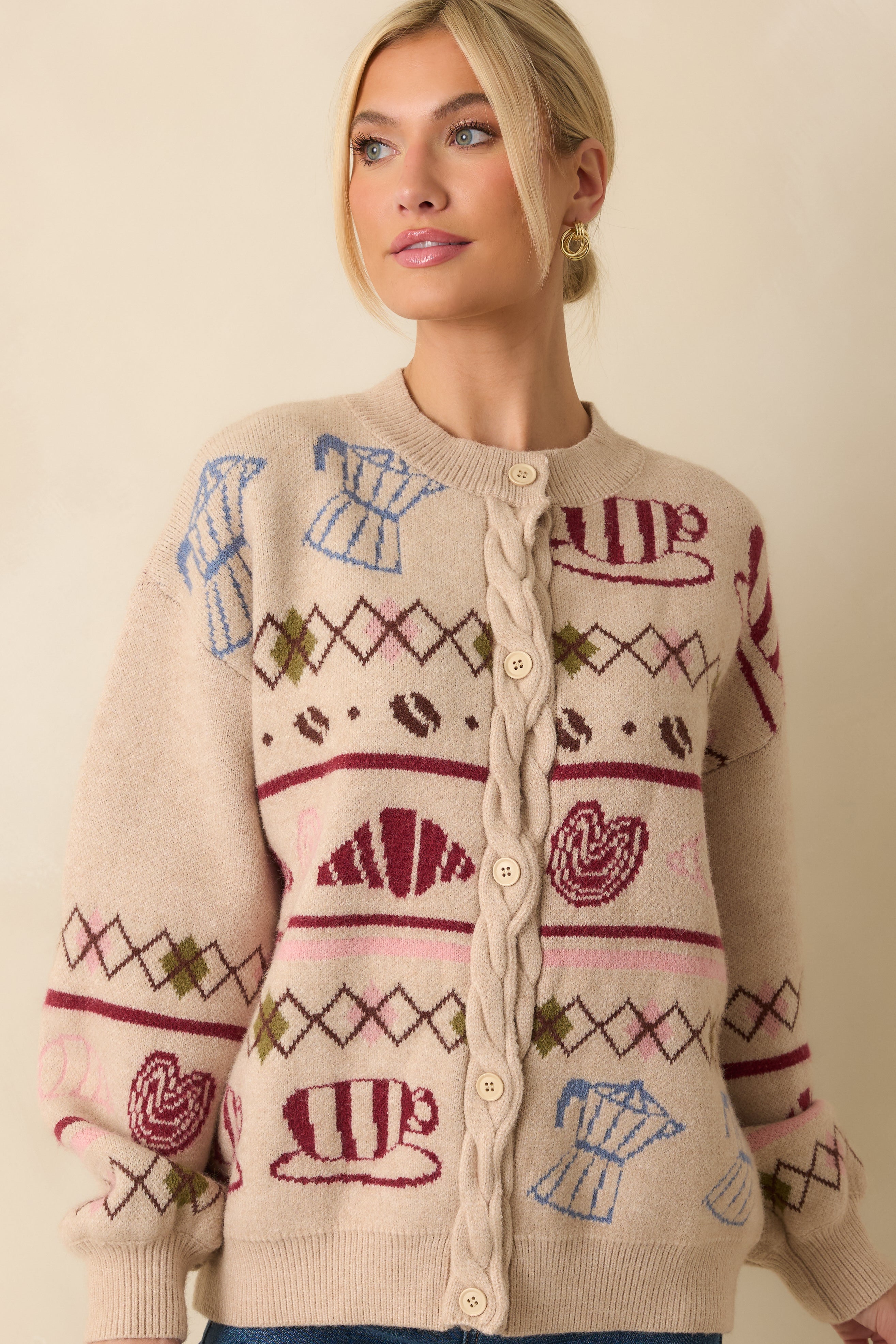 Closer look at the coffee and pastry motif woven across the front of the beige cardigan