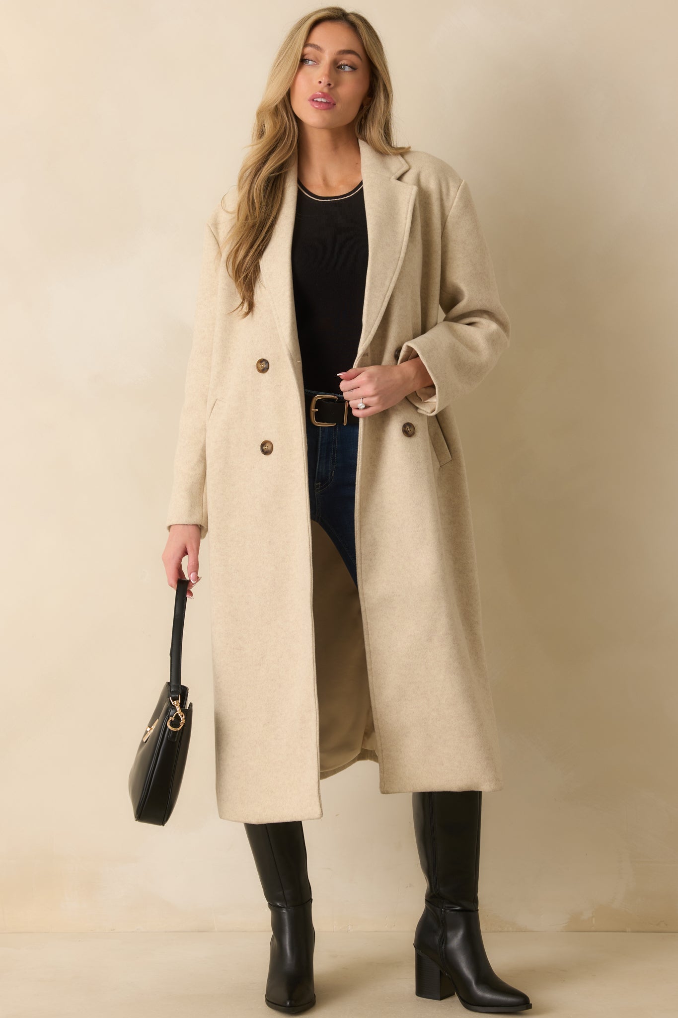 Light beige longline coat showcasing its refined notched lapel collar and smooth drape with a structured silhouette.